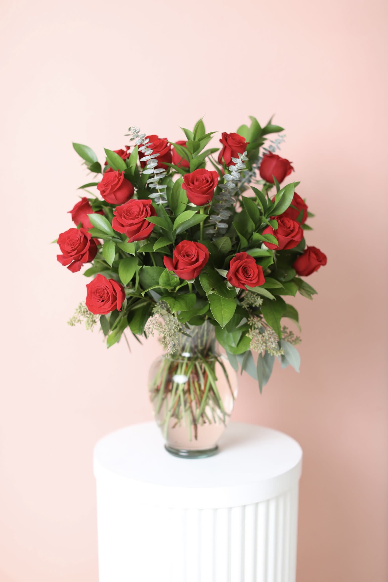 Red roses arranged in a clear glass vase