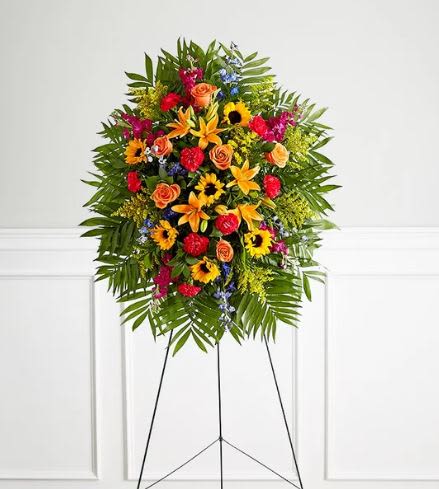 Vibrant Funeral Standing Spray -  Pet Friendly? No - This arrangement contains lilies, which are highly toxic to cats, and delphinium, which can be harmful to dogs and cats if ingested.  Keep out of reach of household pets; it is best suited for funeral home or church environments rather than pet-owning homes.   Human Allergy Note : Contains pollen-heavy sunflowers and lilies. We recommend keeping the arrangement in a well-ventilated area and avoiding direct contact with bedding or upholstery to prevent pollen staining or irritation.   Care &amp; Longevity : This spray is arranged in water-saturated floral foam to maintain its vertical shape. To maximize longevity, gently pour a small amount of fresh water into the back of the foam cage daily. Keep the arrangement away from direct sun, heat sources, or air vents.   Best Occasions &amp; Situations : - Funeral service - Celebration of life ceremony - Memorial service at a church - Graveside service tribute - Final farewell for a vibrant personality - Large-scale altar display   Why Customers Love It : - High-Impact Presence: Standing nearly five feet tall, it makes a significant and respectful visual statement. - Celebratory Mood: The vibrant color palette offers a more uplifting alternative to traditional white funeral flowers. - Sturdy Display: Comes pre-mounted on a professional wire easel for immediate, worry-free setup. - Texture &amp; Depth: A rich variety of spikes, round blooms, and lush greenery creates a professional, high-end look.