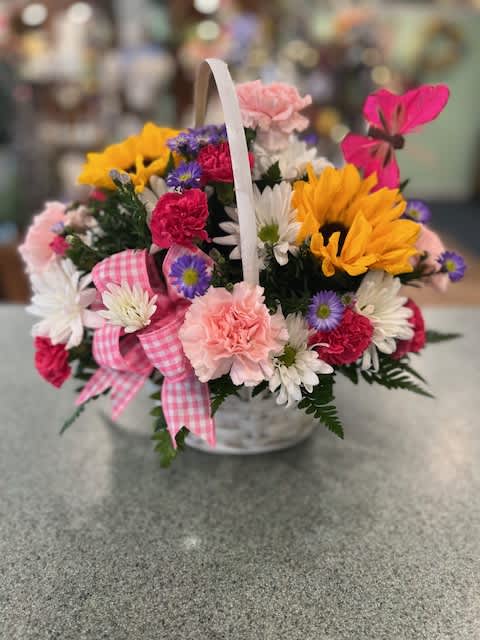 Basket of mixed flowers with a pink gingham ribbon