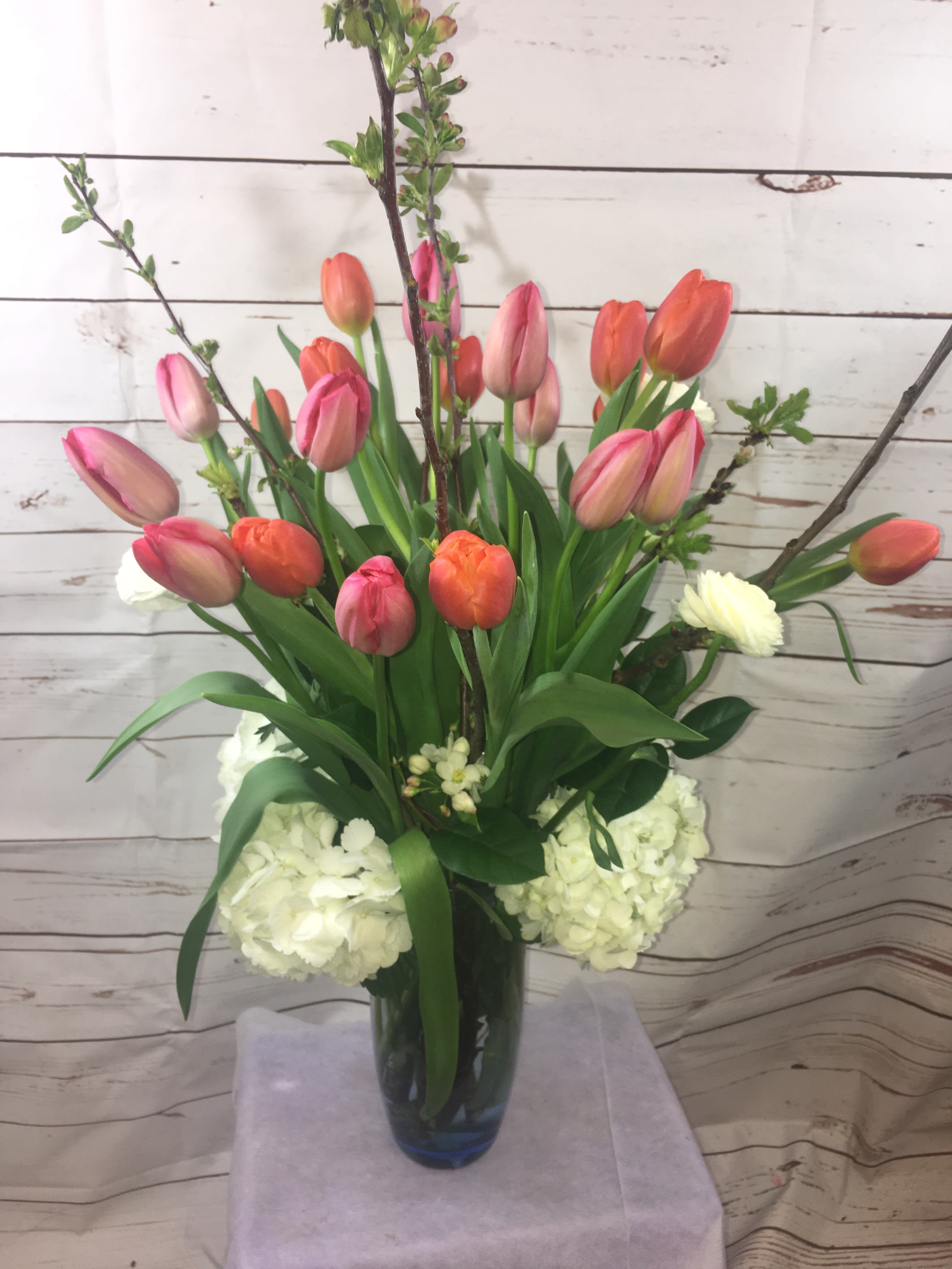 Tulip arrangement in a glass vase with white hydrangeas