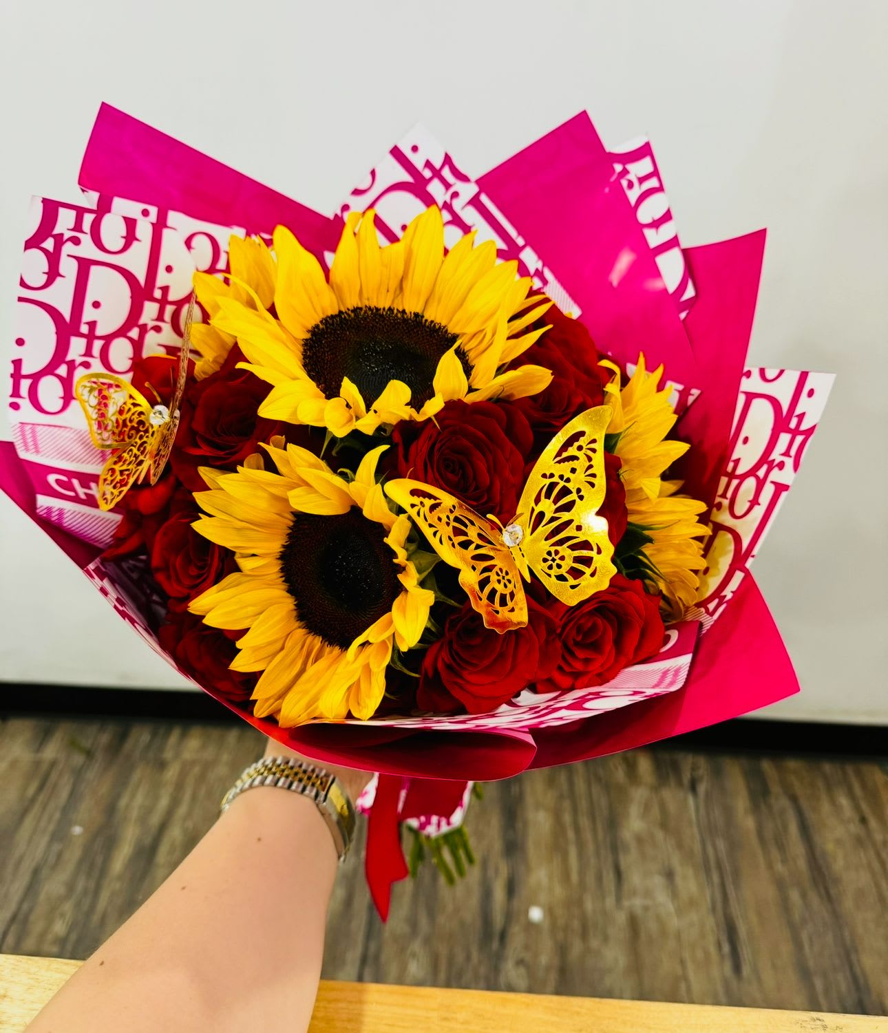 My pretty Woman - Give this charming mix bouquet of 5 sunflowers and 24 premium red roses matching with two butterflies gold toppers!