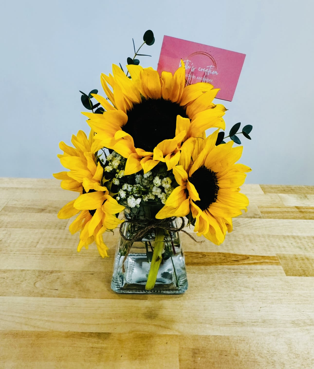 Shine yellow  - A beautiful and  cozy little jar with these 3 beautiful sunflowers and a touch of white baby breath and some yellow green fillers.