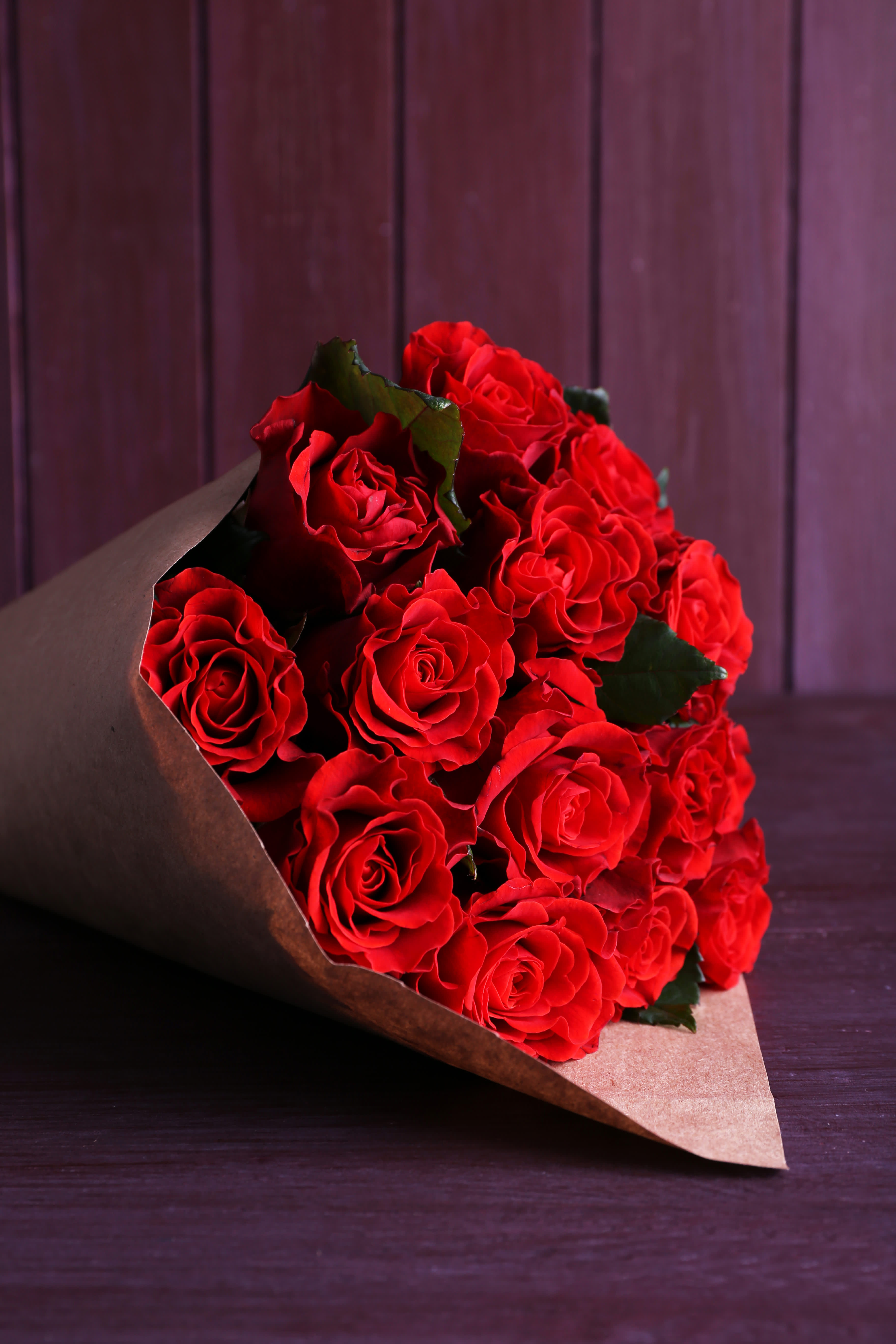 24 Wrapped Red Roses - Delight him or her with 24 gorgeous red roses wrapped in kraft paper and tied with twine ! This Bouquet does not include a vase.