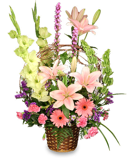 Basket of Memories - This arrangement is an elegant tribute to the favorite times in our lives with the ones we love most. As our best memories stand out in our minds, pink and purple lilies, gladiolus, gerbera daisies and Bells of Ireland are arranged to grab your attention in this stunning flower arrangement. A grapevine fashioned into a faux handle for the basket brings the arrangement full-circle as a visual collection of memories in this simple wicker basket.
