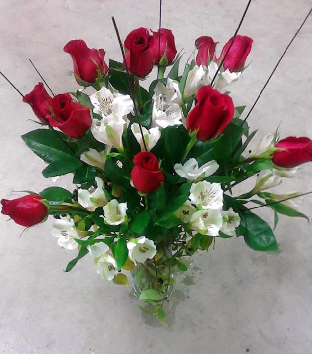 Bouquet of red roses and white alstroemeria in a clear glass vase