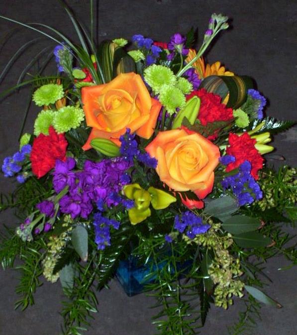 Colorful bouquet with orange roses, purple flowers, and green accents