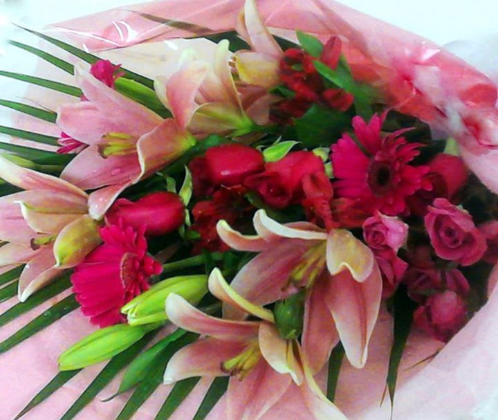 Bouquet of pink lilies and red flowers wrapped in pink paper