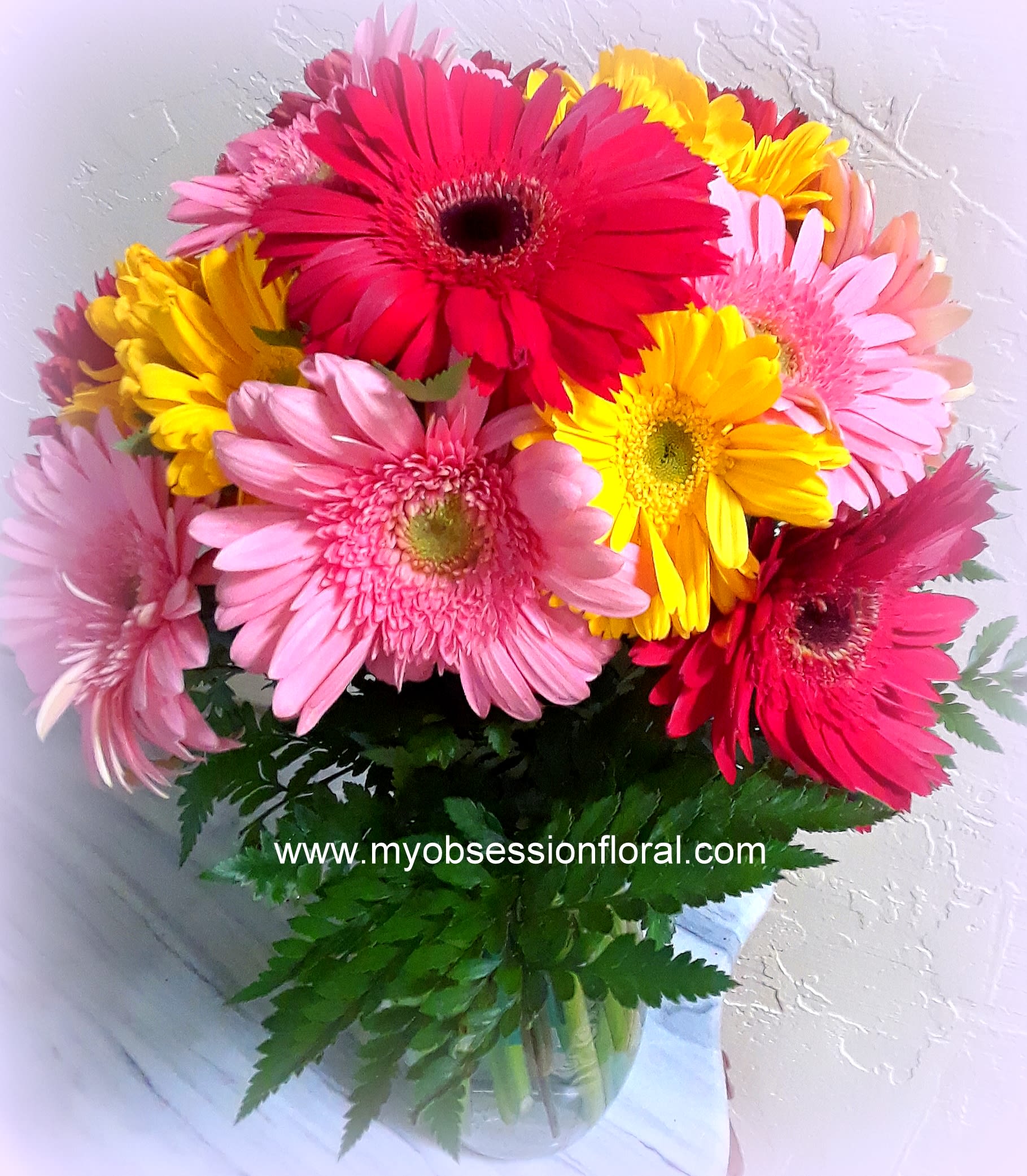 Bouquet of colorful gerbera daisies with green foliage