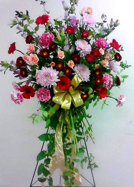 Tall standing floral spray with red, pink, and lavender blooms
