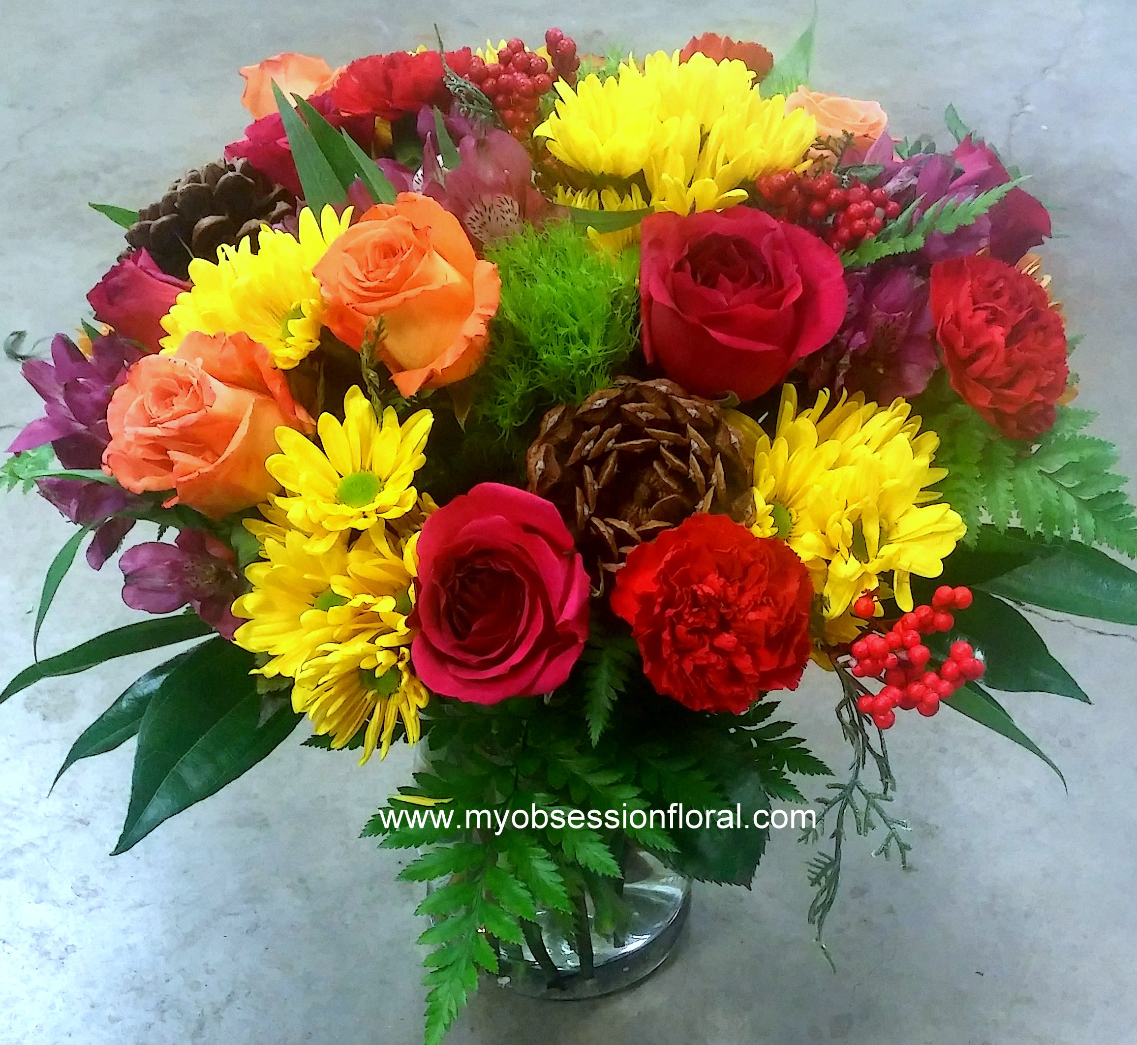 Mixed bouquet of roses and yellow daisies in a glass vase