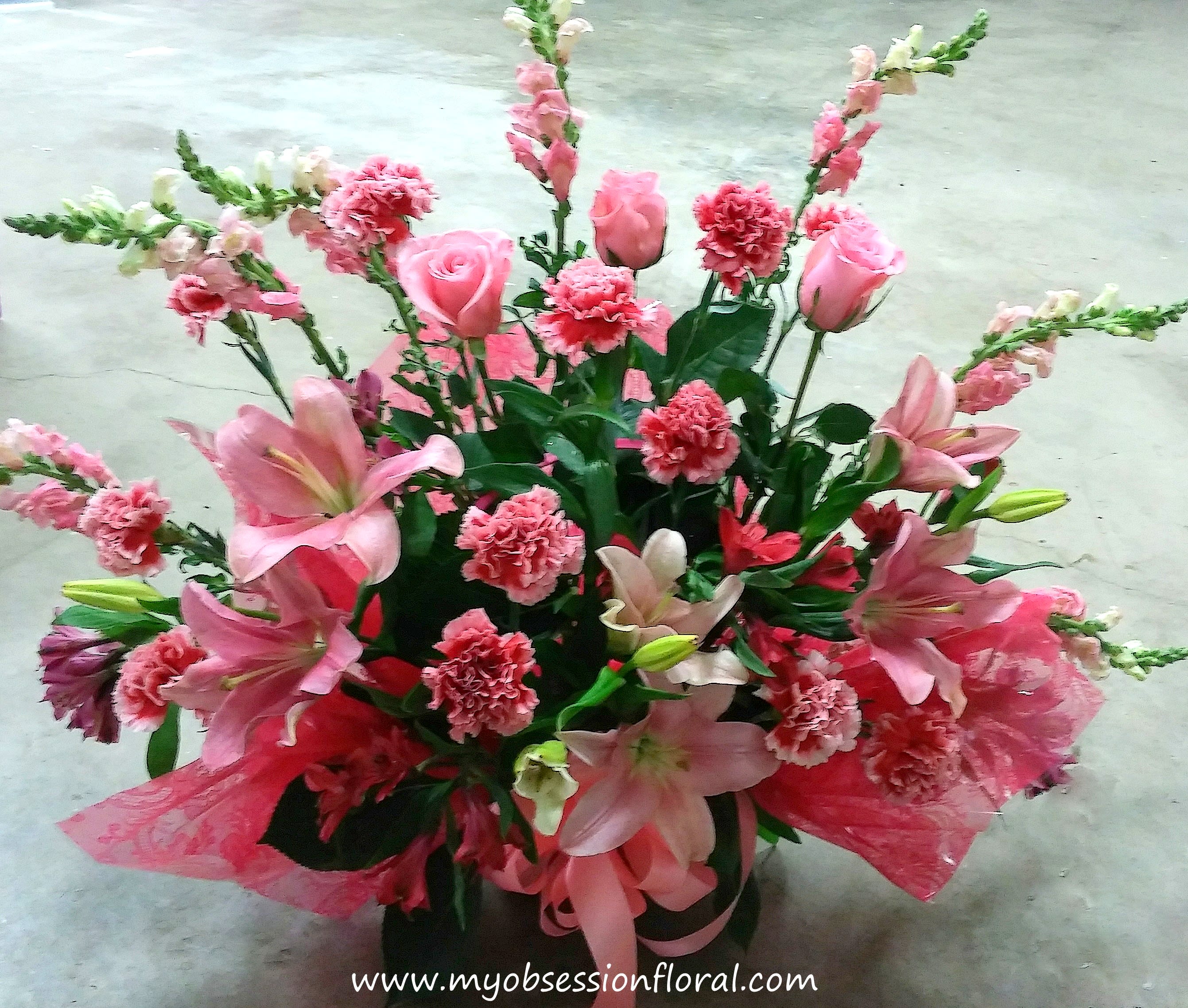Pink lilies, roses, and carnations in a decorative bouquet