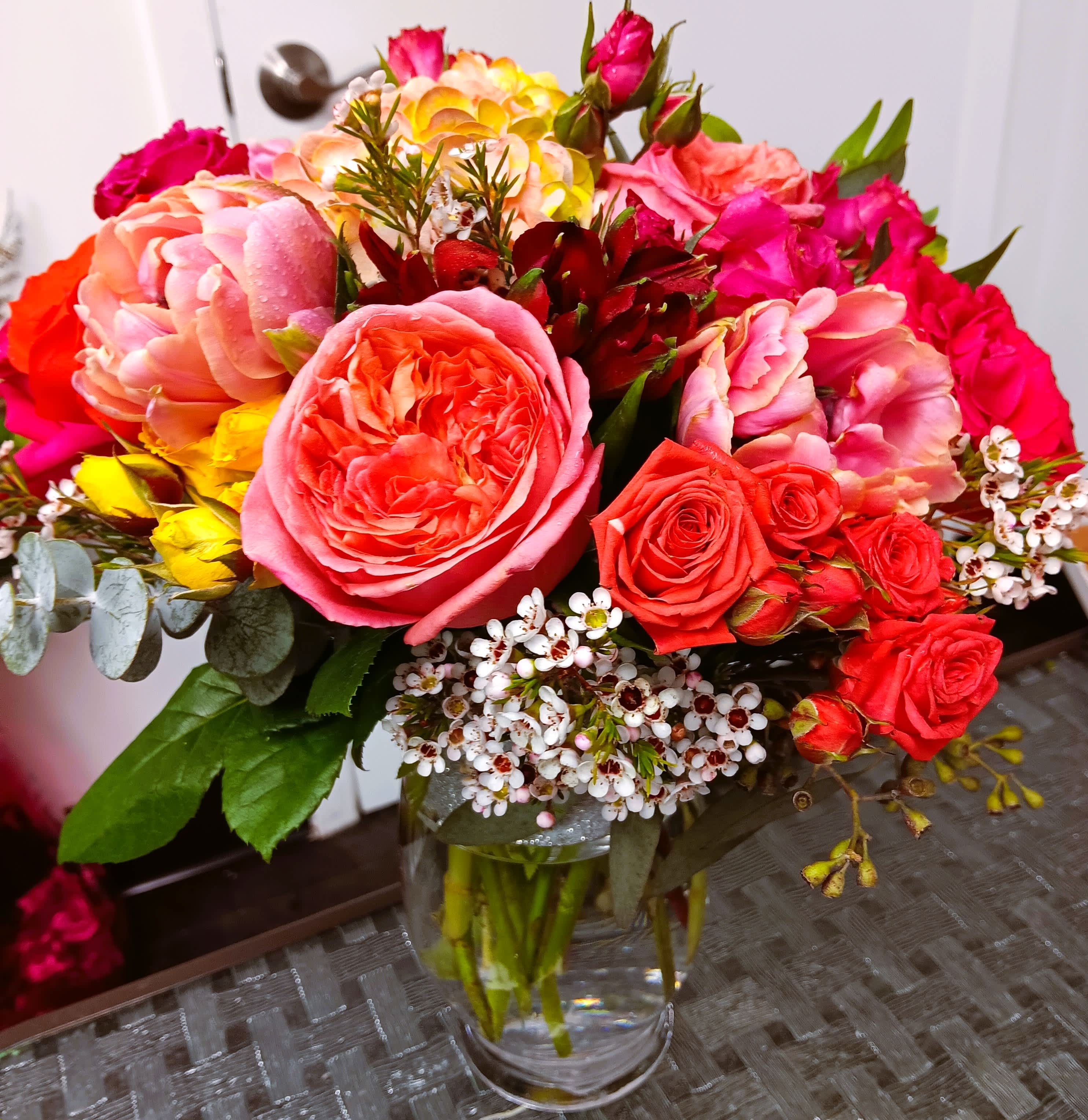 Mixed bouquet of pink and red roses in a clear glass vase