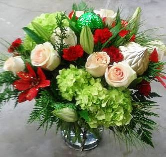 Bouquet of white roses, red flowers, and green hydrangeas in a vase