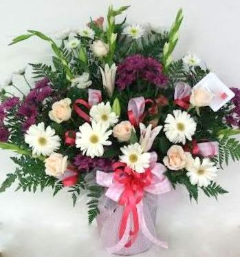 Bouquet of white daisies and pale roses with purple flowers in a vase