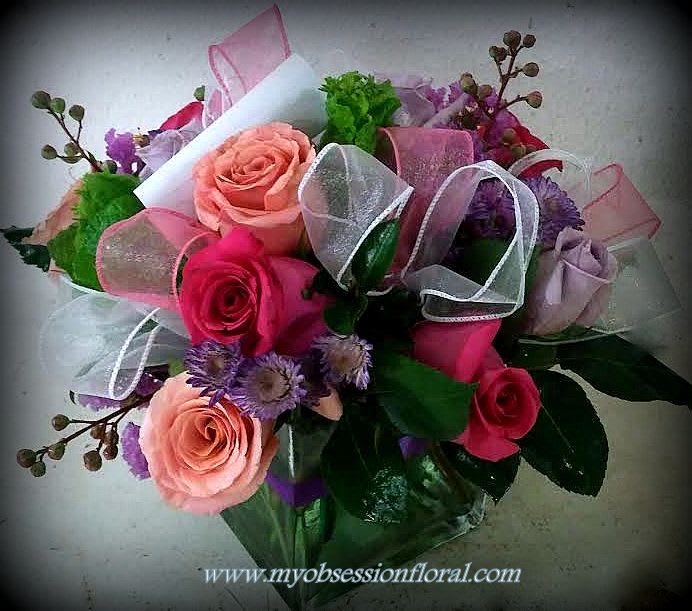 Bouquet of pink and peach roses with purple flowers and ribbon wrap