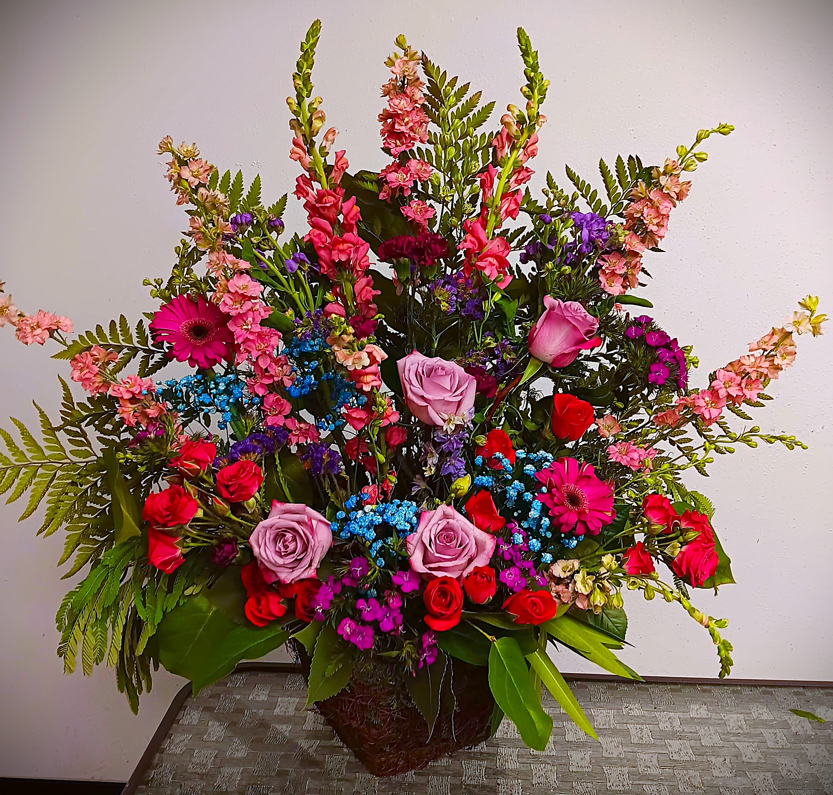 Large mixed bouquet with roses, gerbera daisies, and snapdragons in a basket
