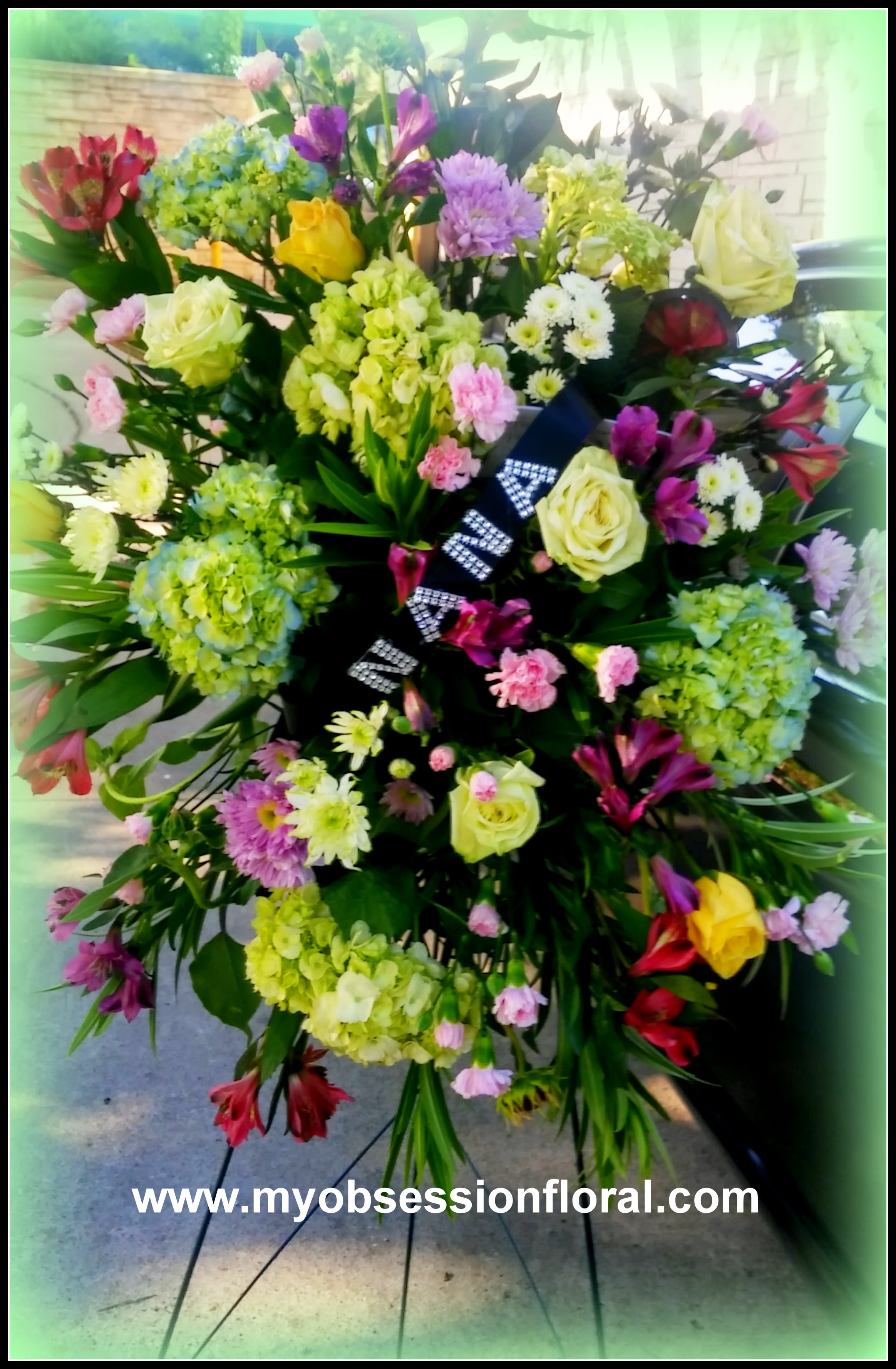 Large standing floral spray with roses, hydrangeas, and mixed blooms