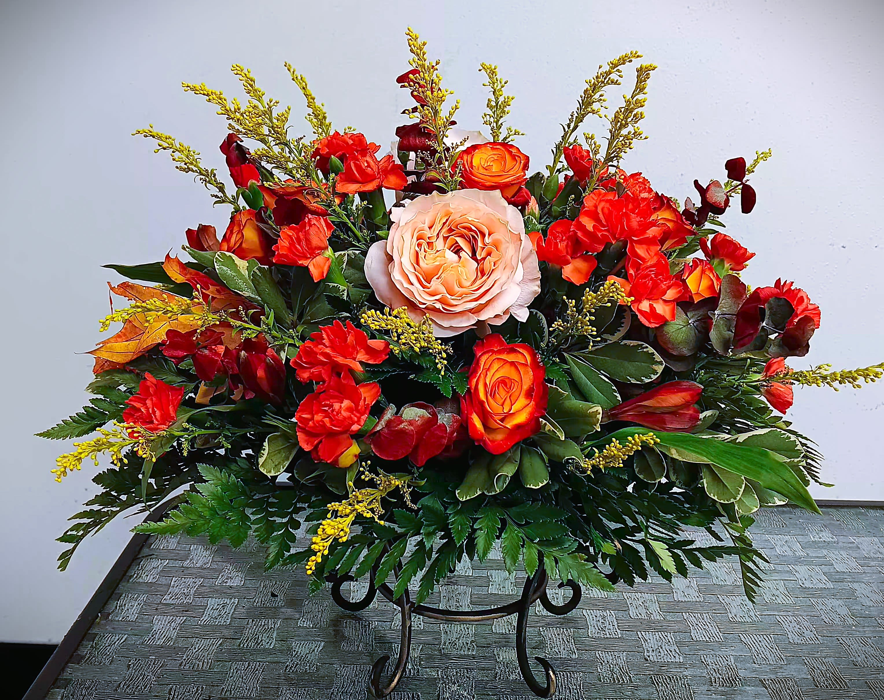 Large arrangement of red and orange roses with a pale peach rose center