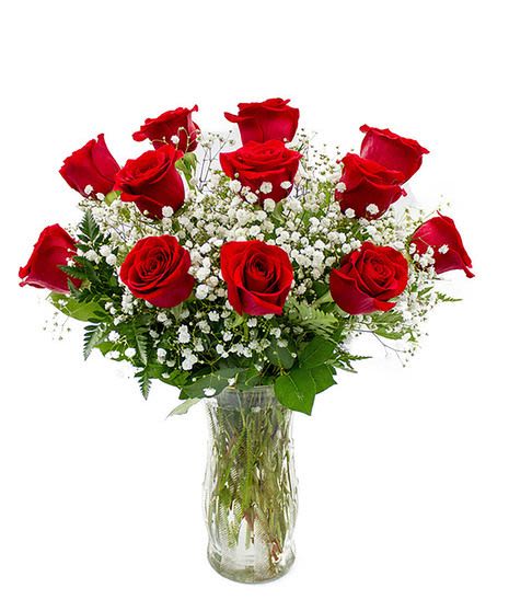 Red roses arranged in a clear glass vase with white baby's breath