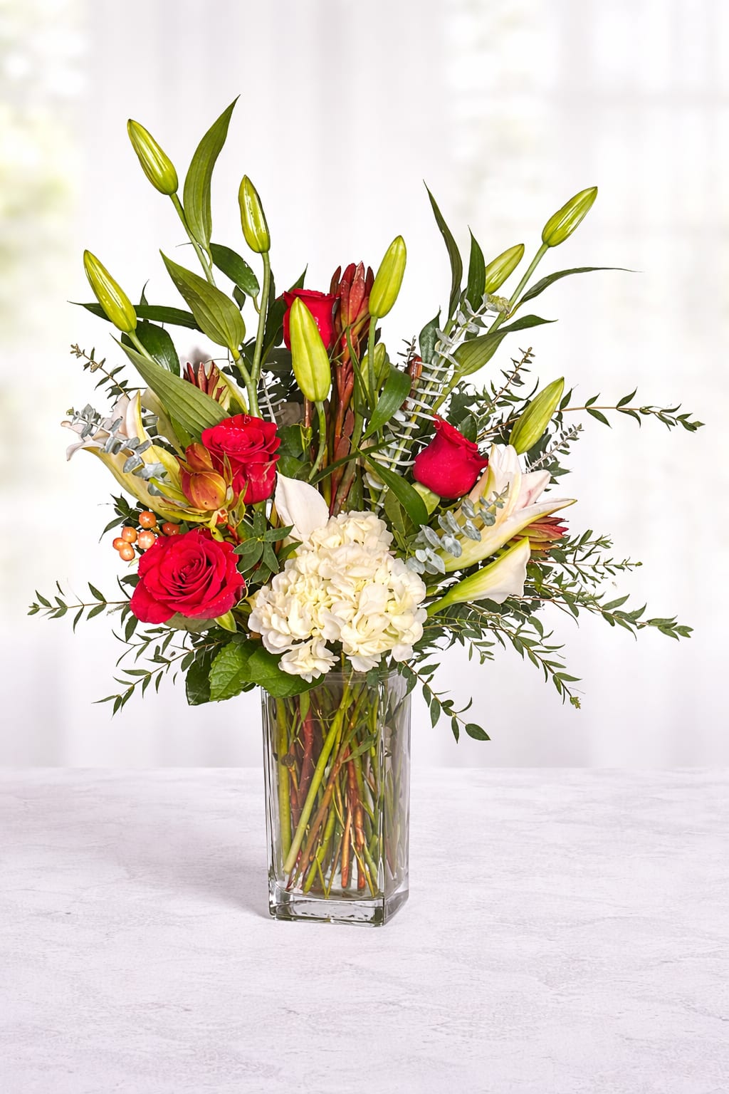 Classic Red Rose, Stargazer &amp; White Calla Lily Arrangement - Order fresh flowers online from a trusted local Omaha florist. This premium bouquet features vibrant red roses, elegant white Calla and stargazer lilies, lush hydrangeas, and seasonal accent blooms, all arranged in a modern square glass vase with eucalyptus and natural greenery. Perfect for Omaha birthdays, anniversaries, romance, sympathy, corporate gifting, weddings, and everyday home décor. Available for same day delivery throughout the Omaha metro area ordered by 12 Noon . Hand-designed with care by Purple Orchid Flowers, proudly serving Omaha, Nebraska. 