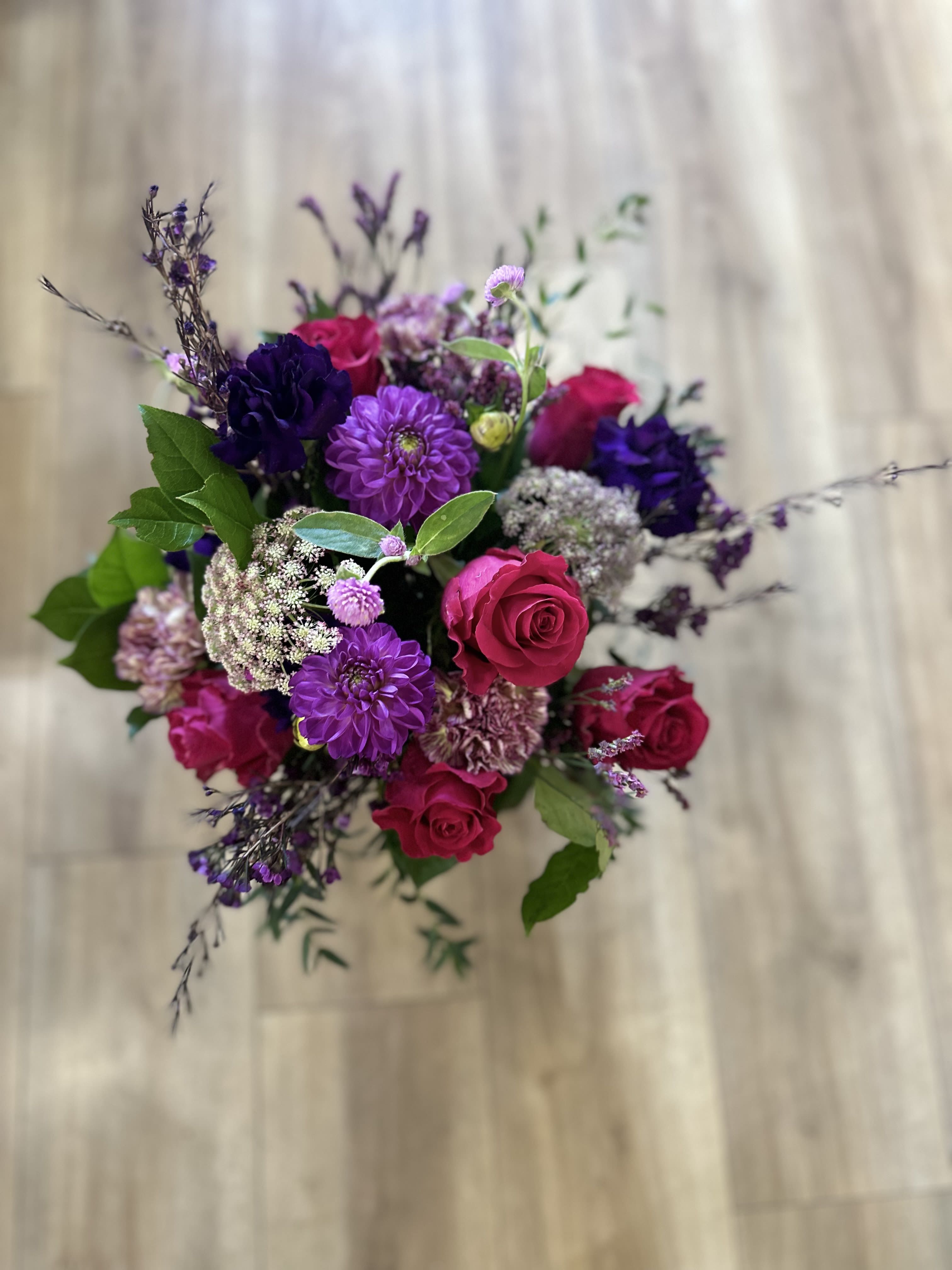 Bouquet of pink roses and purple flowers with greenery