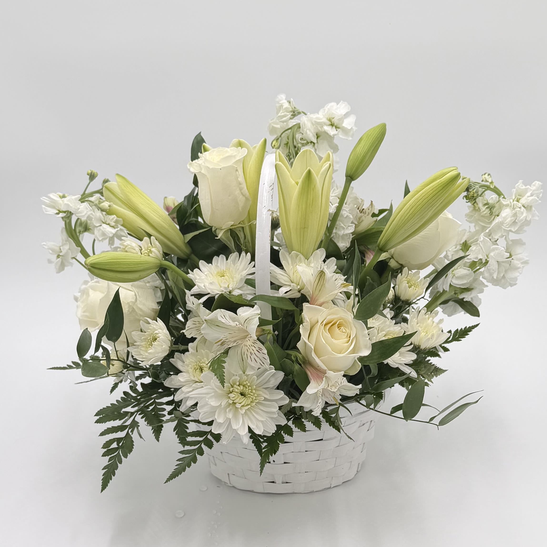 Serenity and Love - Embrace a feeling of serenity and love with this serene basket brimming with white lilies, roses, and daisies. Each delicate bloom exudes purity and grace, creating a tranquil ambiance that soothes the soul. Let this heartfelt arrangement convey your warmest wishes and bring comfort to those who receive it. 