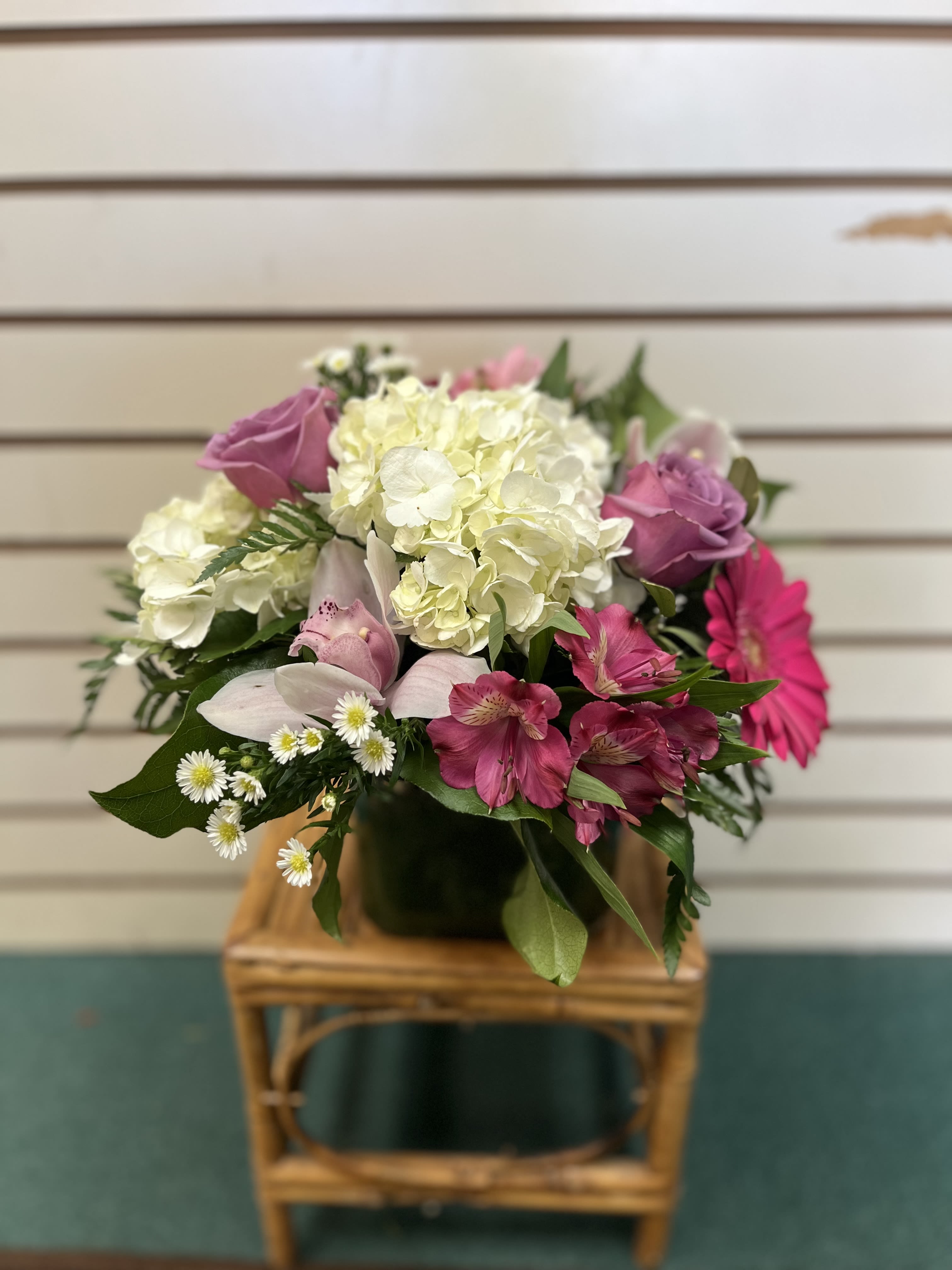 Bouquet of pink and white flowers in a dark vase