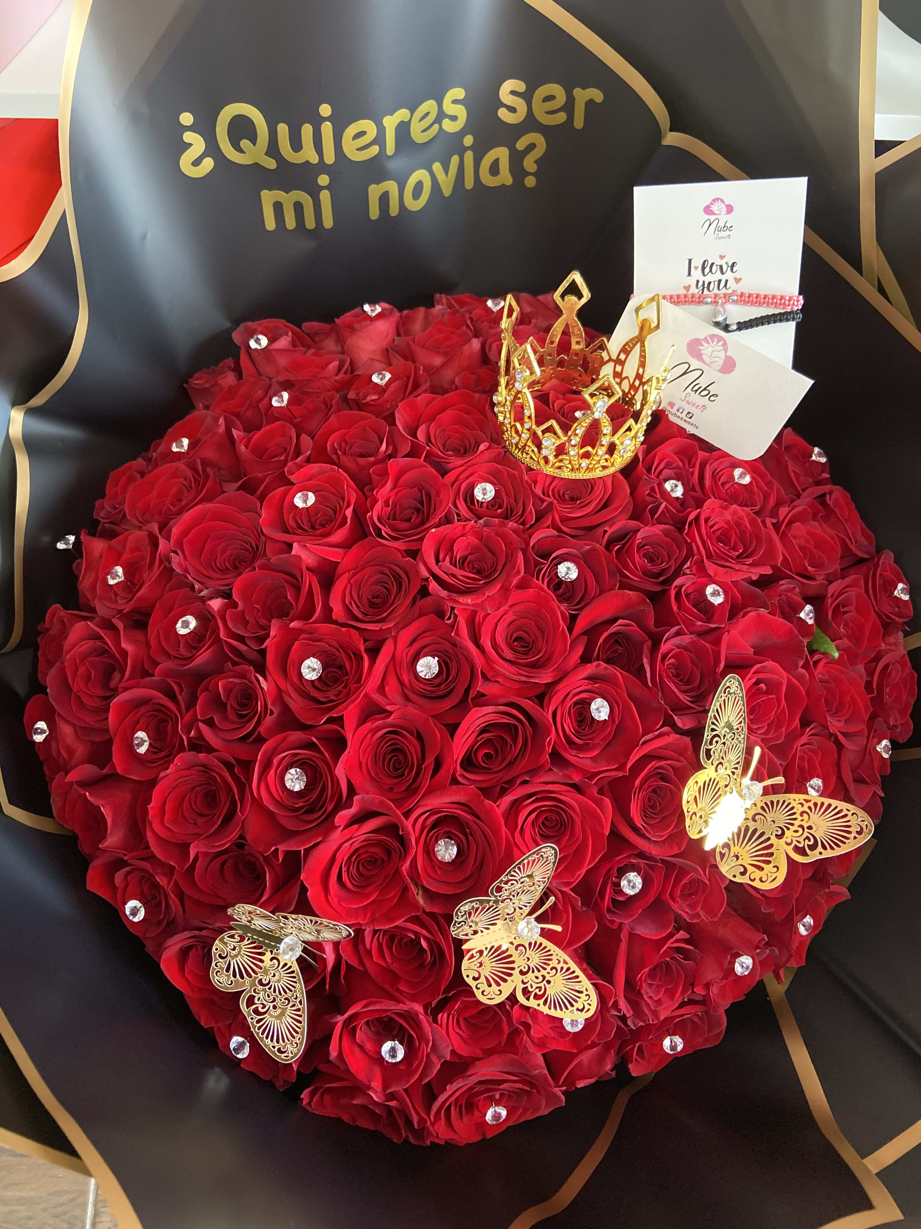 Heart-shaped bouquet of red roses with gold accents and a small crown