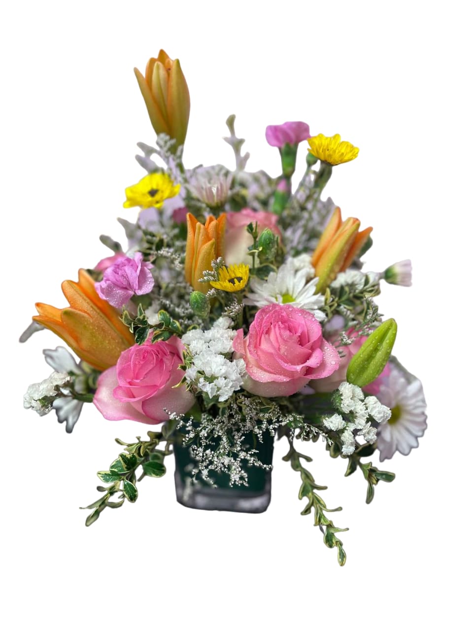 Pink roses and mixed flowers in a small square vase