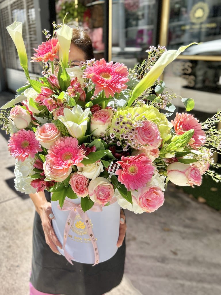 Large pink and white flower arrangement with gerberas, roses and calla lilies in a white hat box