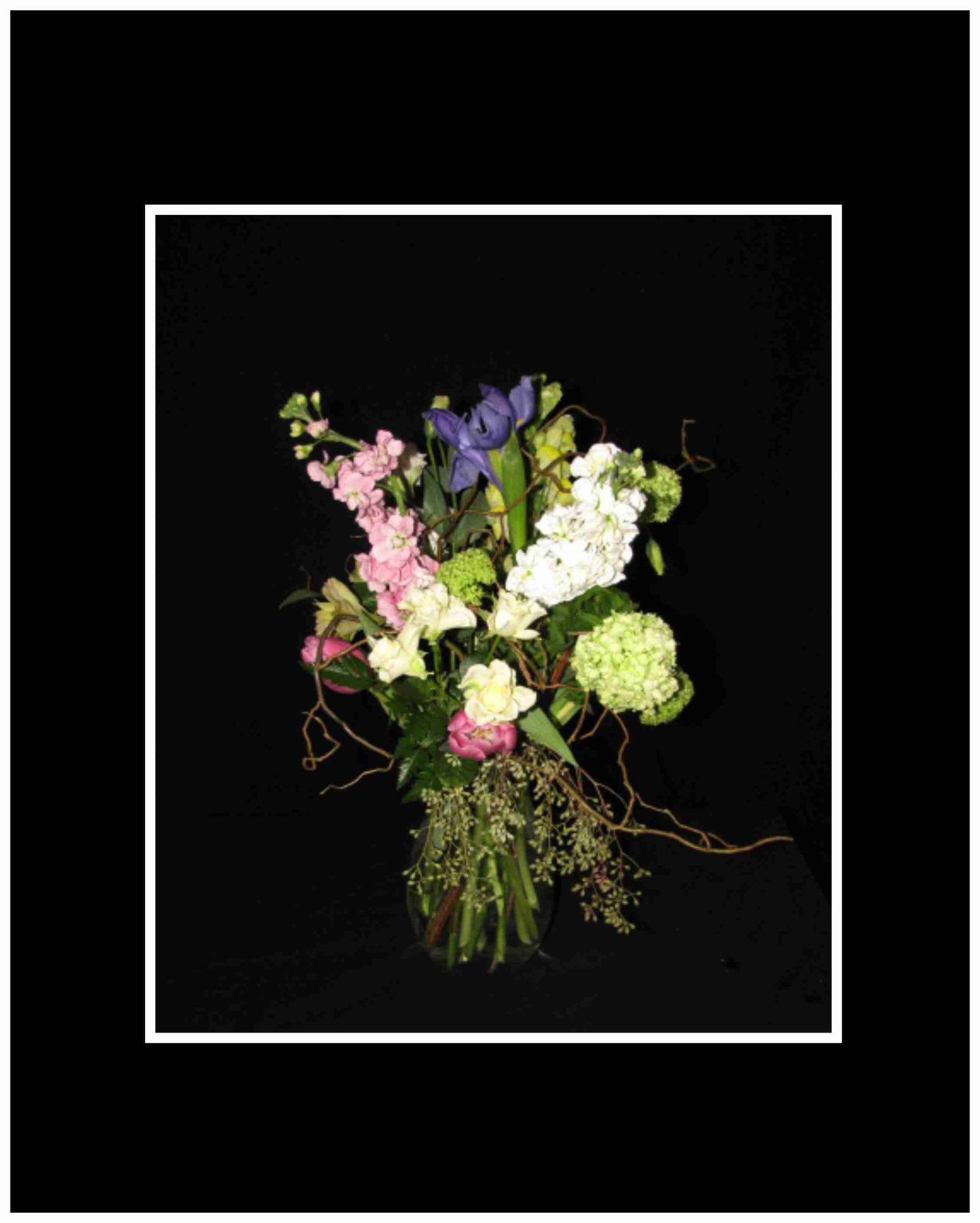 Tall mixed bouquet with pink, white, green, and purple flowers in a vase