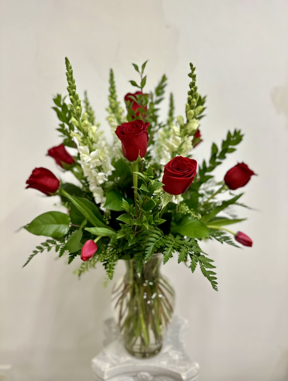 Red roses and white snapdragons in a glass vase