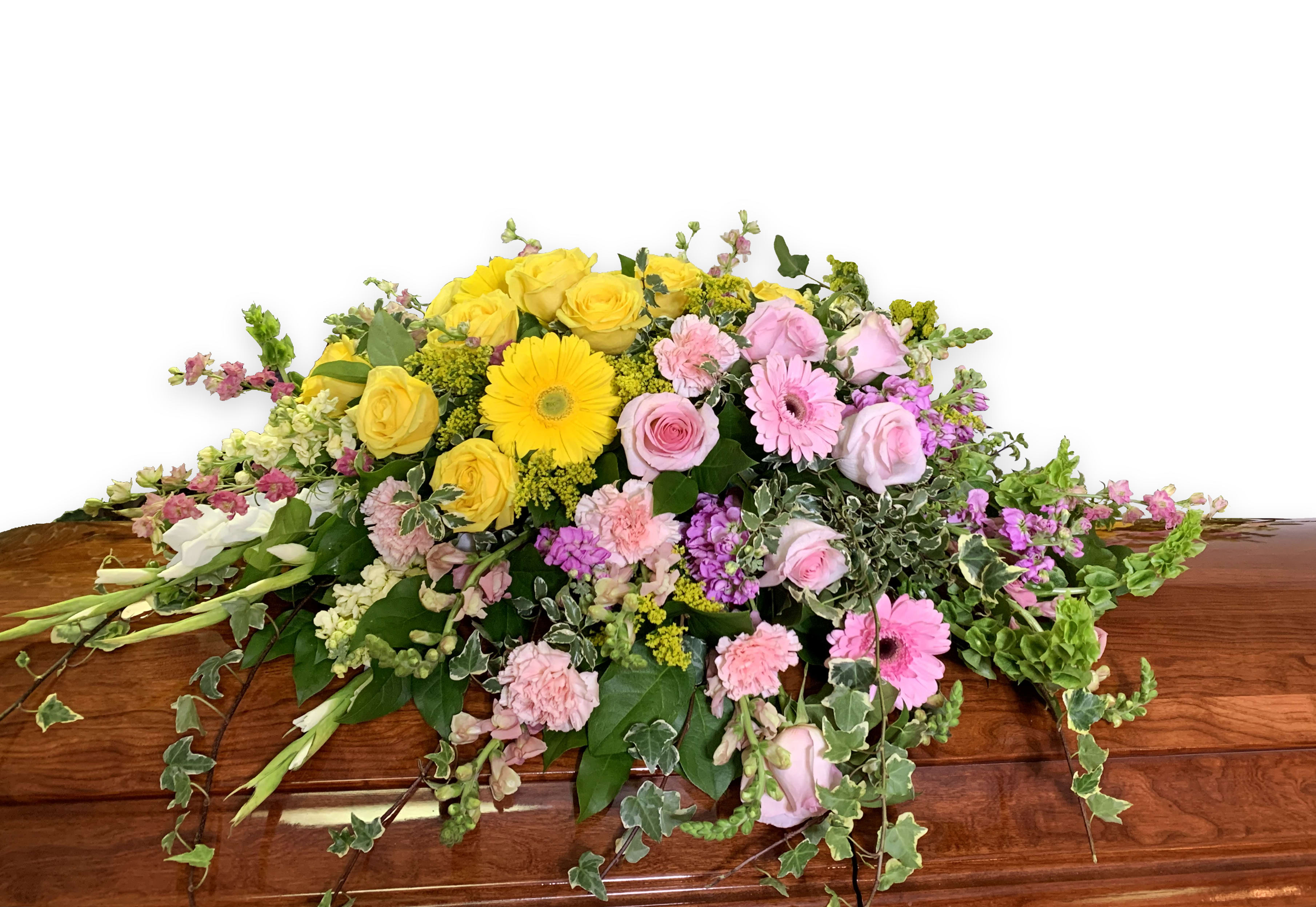 Casket spray with yellow and pink flowers and trailing greenery