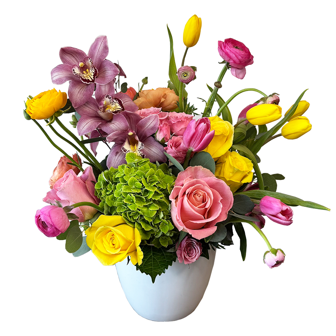 Mixed bouquet of pink, yellow, and purple flowers in a white vase