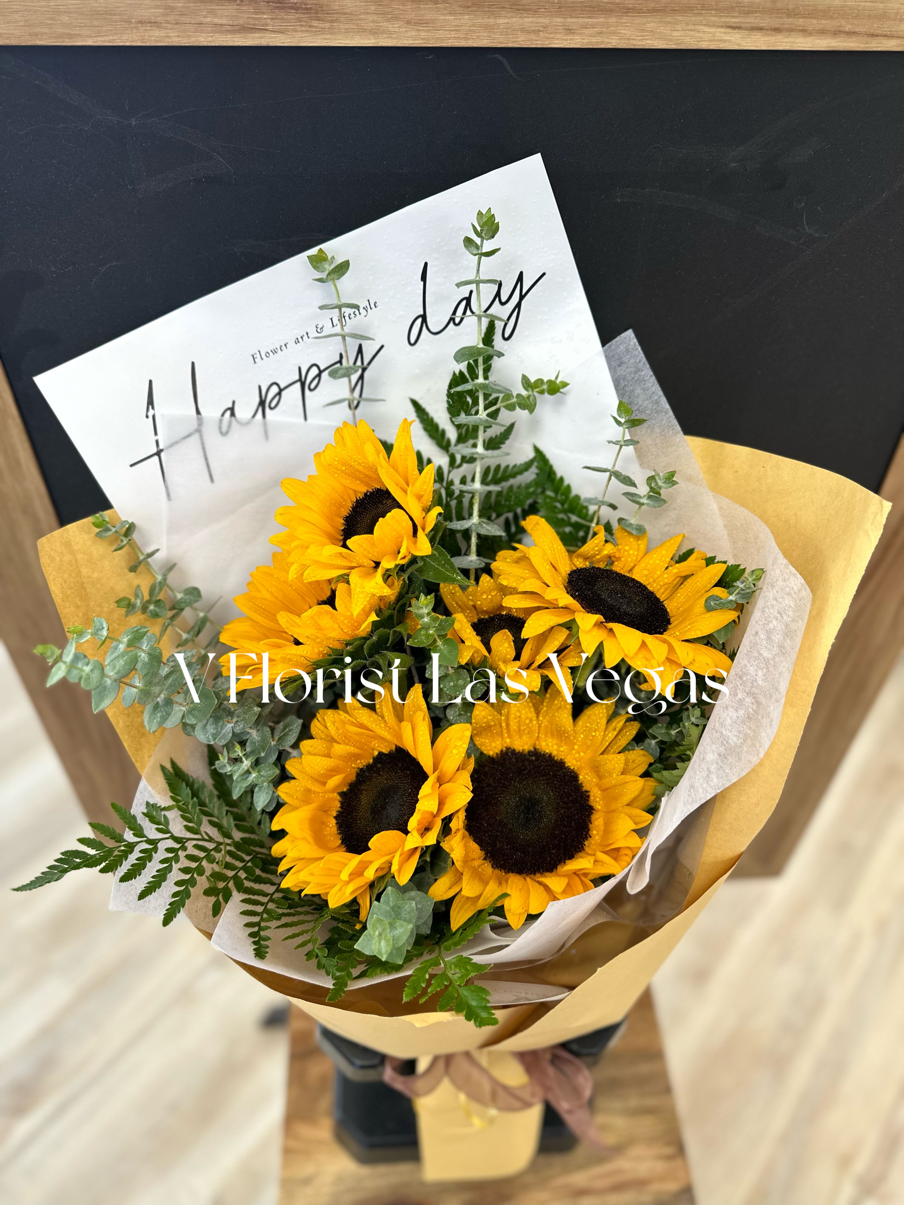 Bouquet of yellow sunflowers wrapped in paper