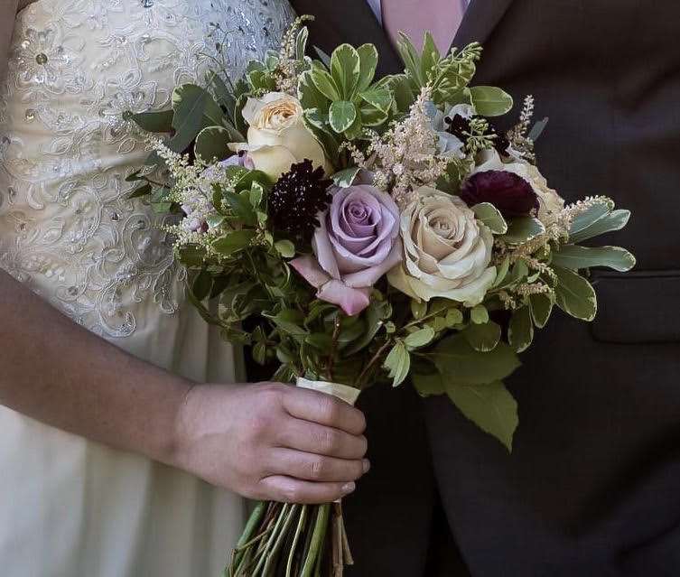 Bride holding a bouquet of roses and greenery