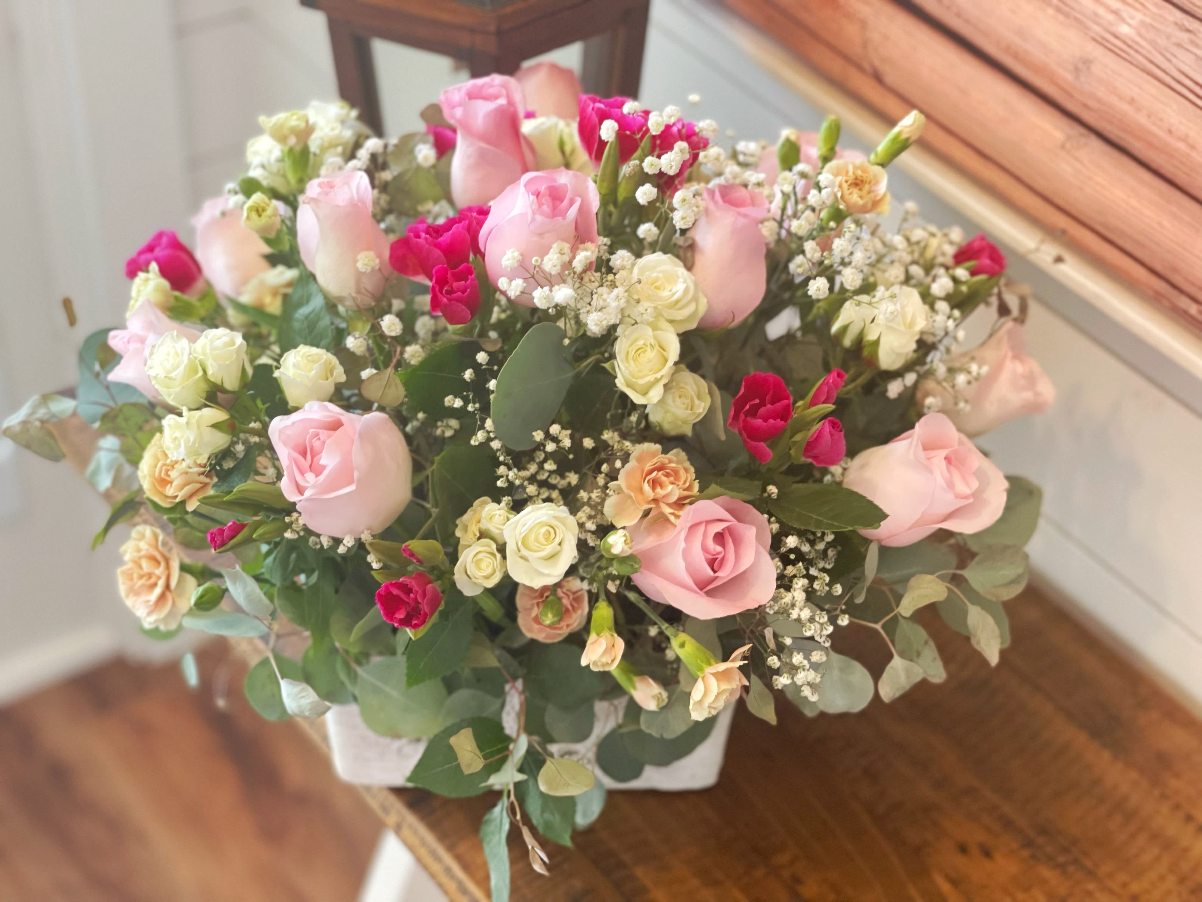Pink and white rose bouquet in a white container