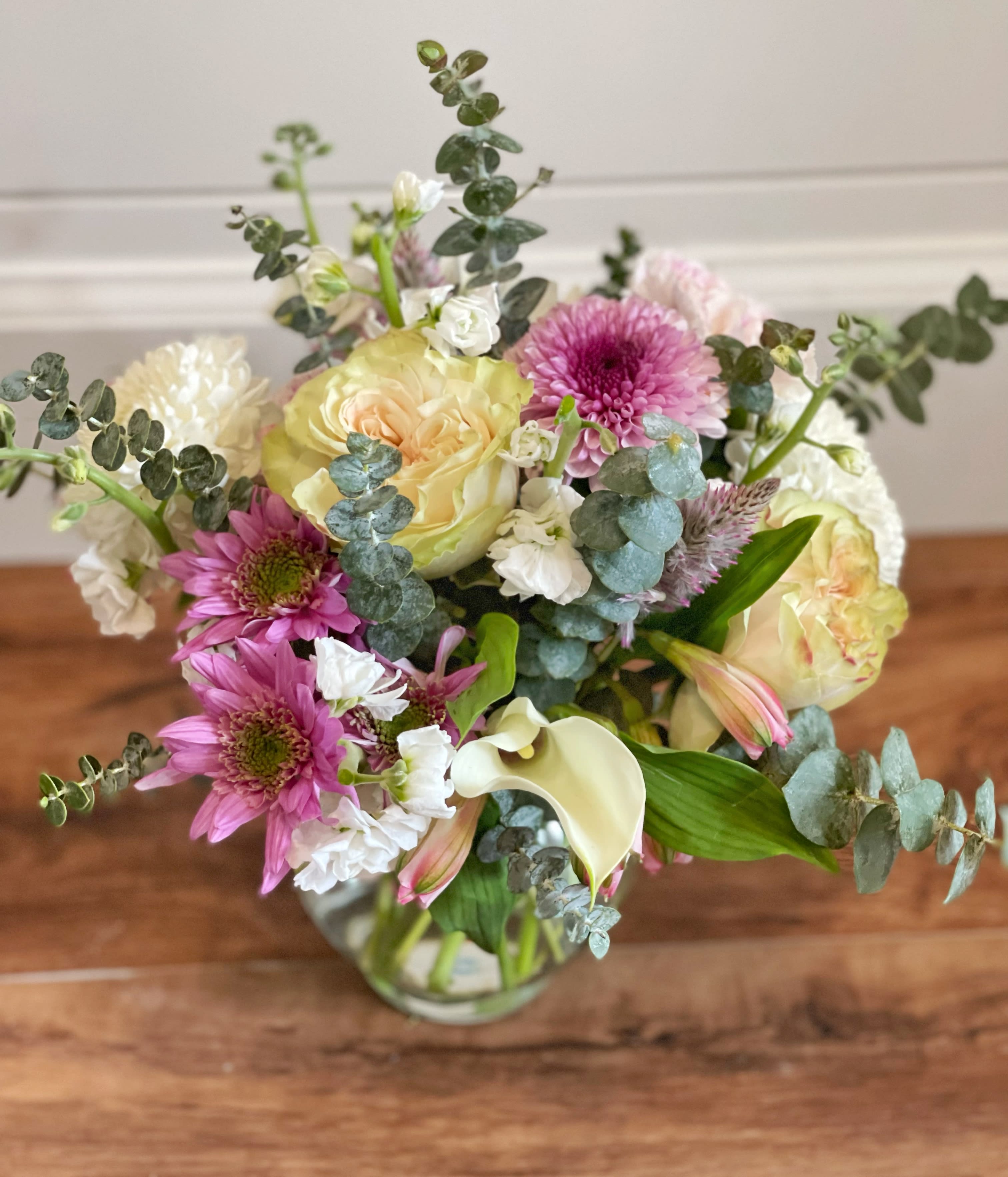 Mixed bouquet of pink and cream flowers in a glass vase