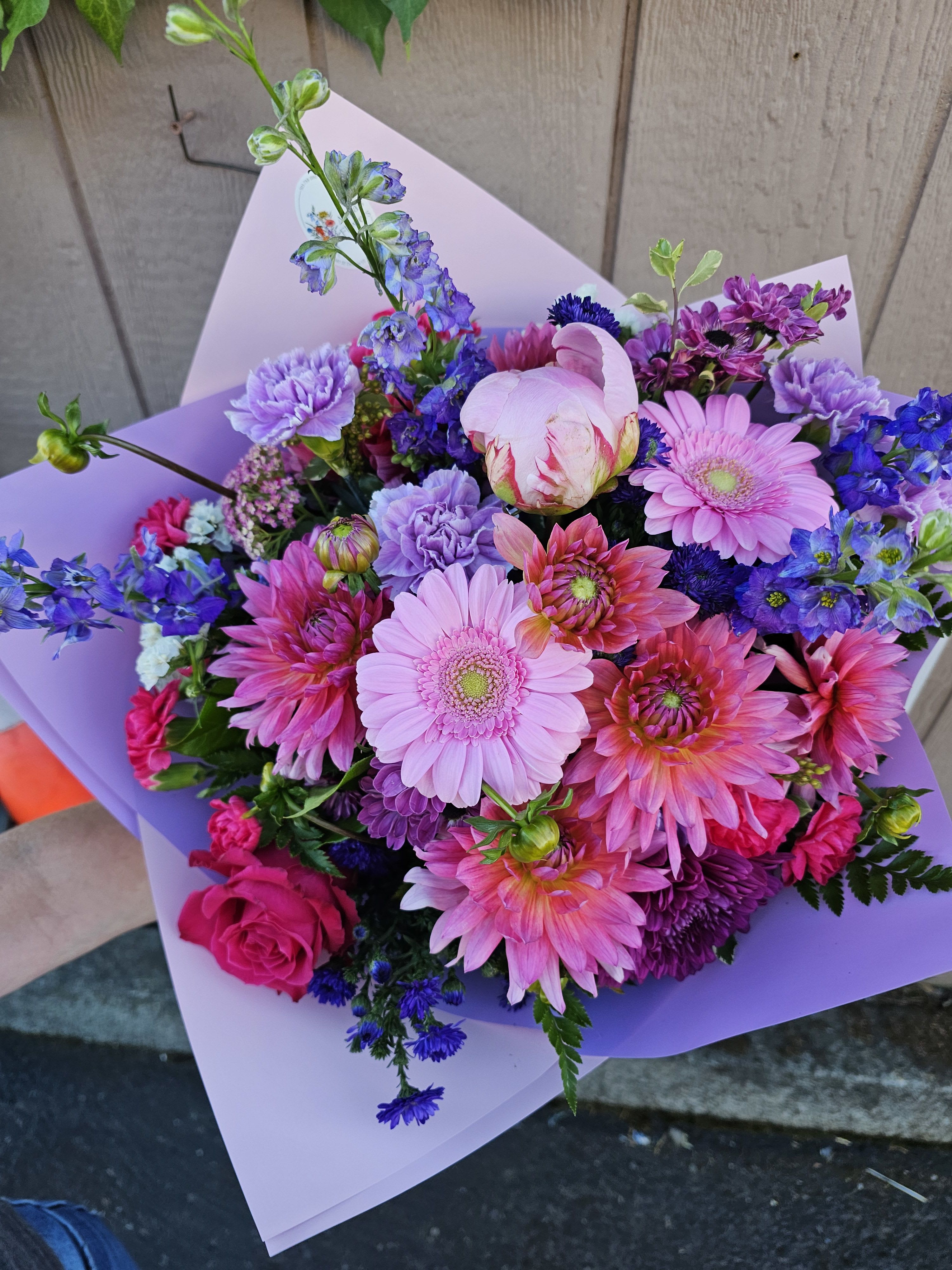 Bouquet of pink, purple, and blue flowers wrapped in lavender paper
