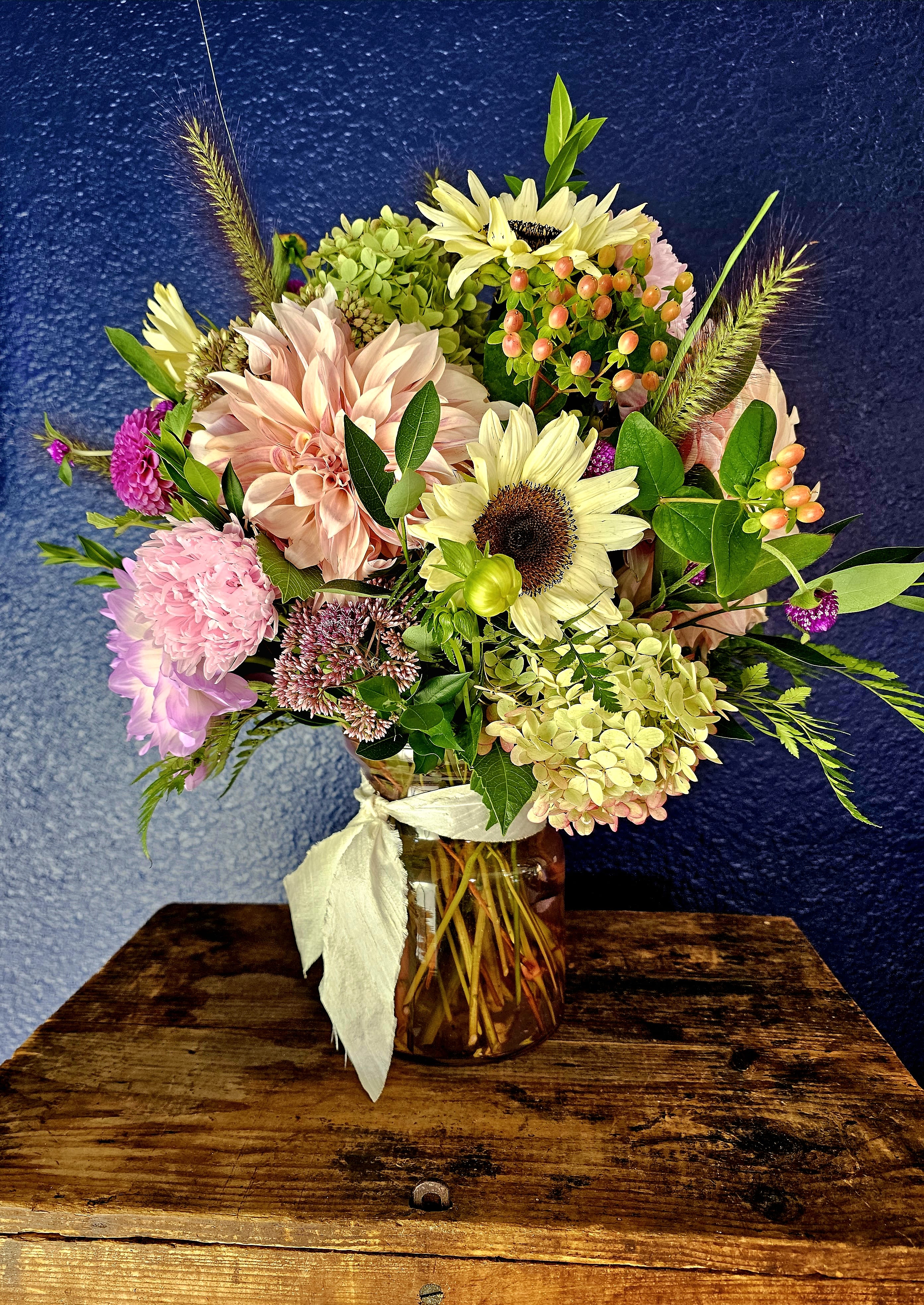 Mixed bouquet in a glass jar vase with pale pink and cream blooms