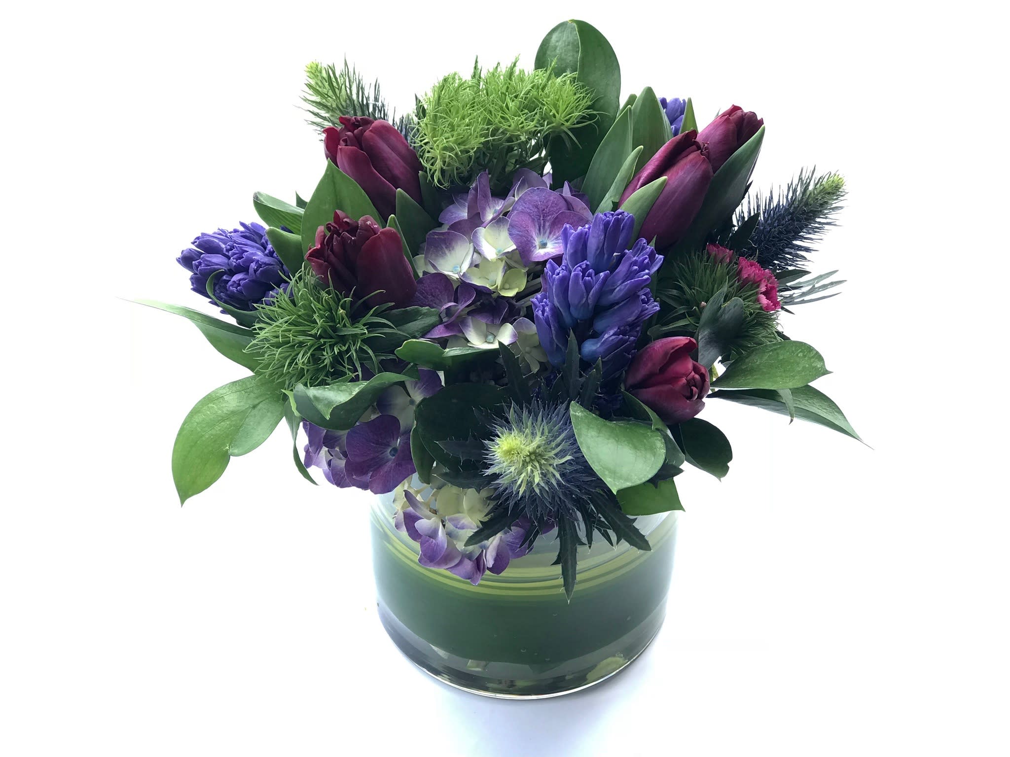Purple and burgundy floral arrangement in a glass vase