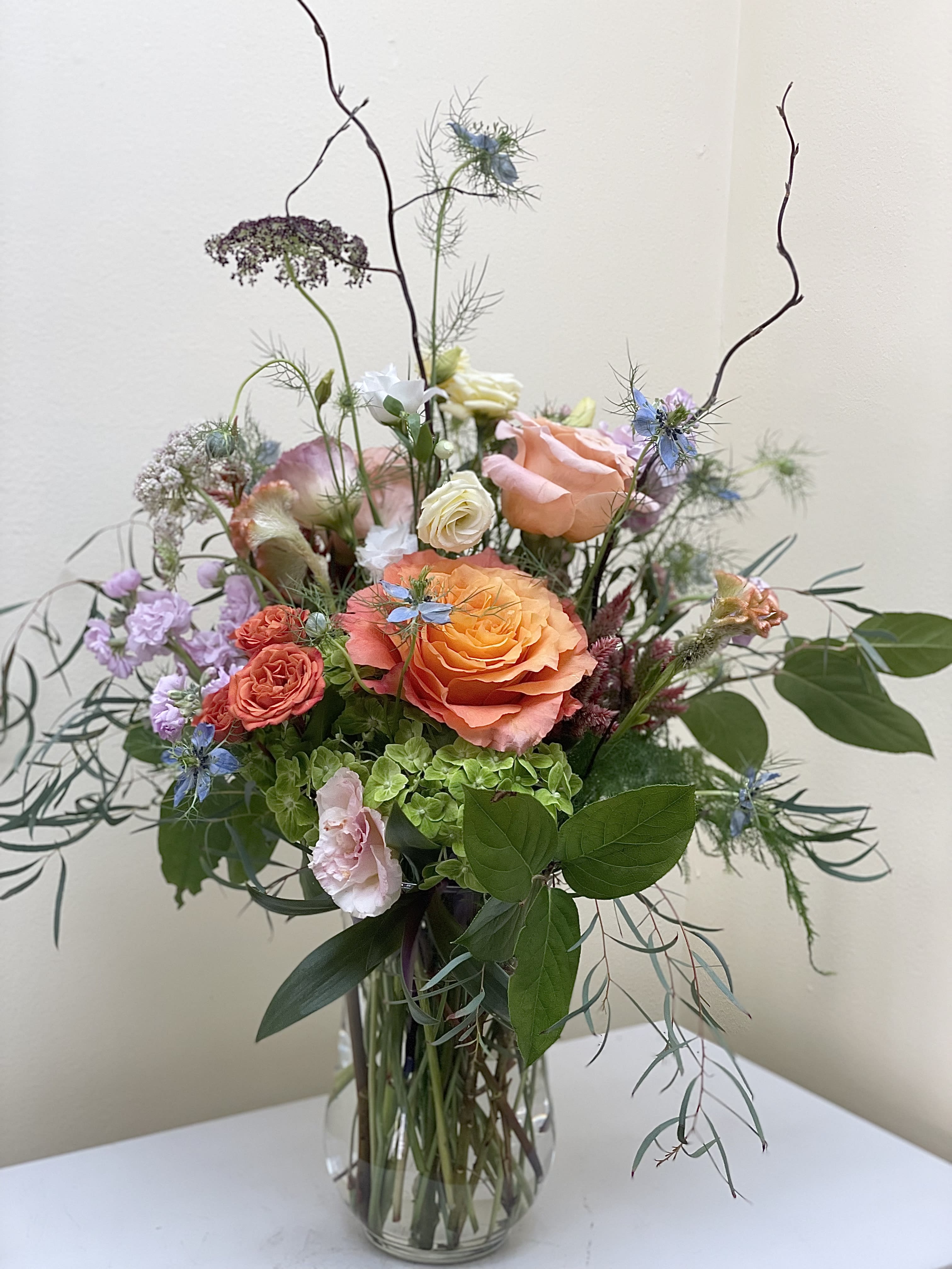 Mixed bouquet of peach and pink roses in a glass vase