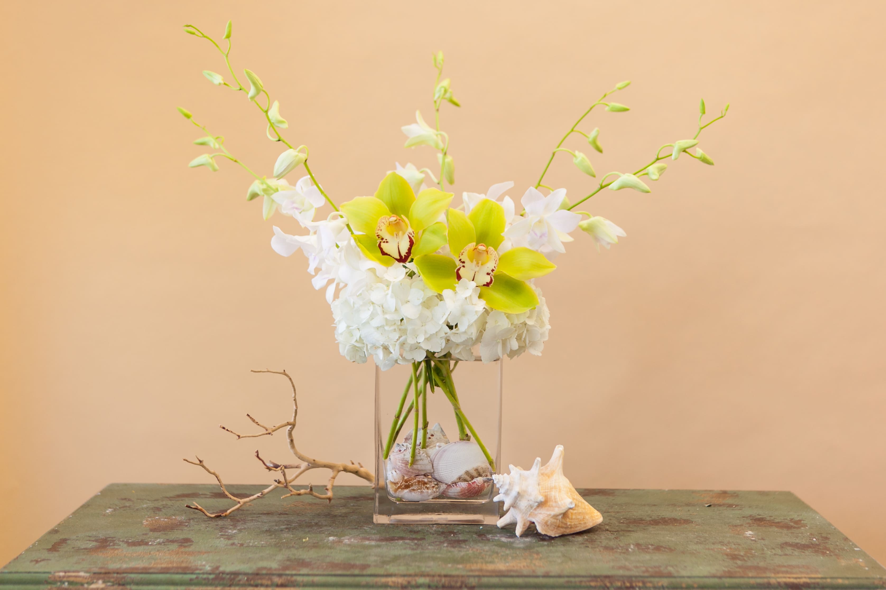 White and lime orchids arranged in a clear rectangular vase