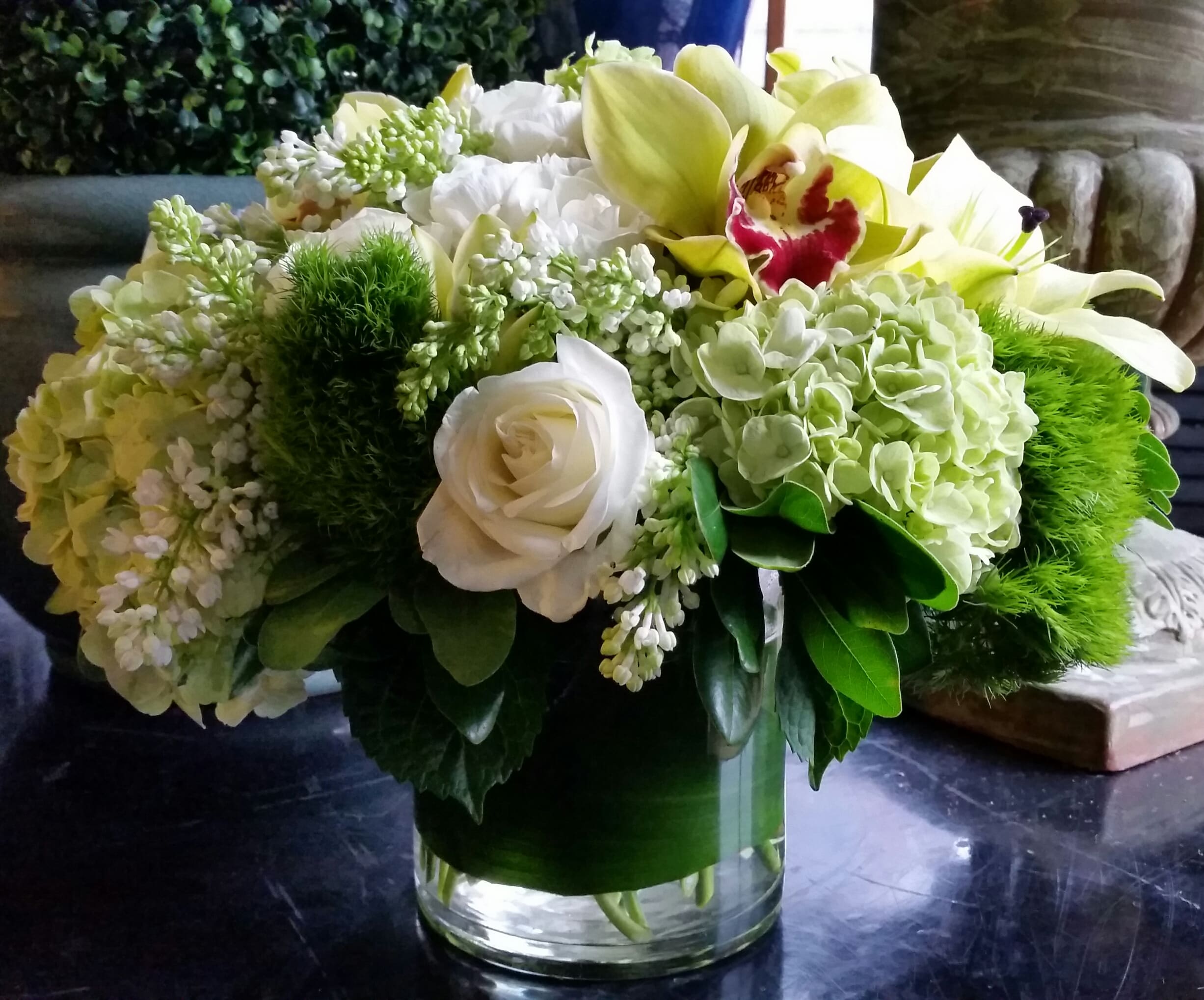 White and green floral arrangement in a clear glass vase