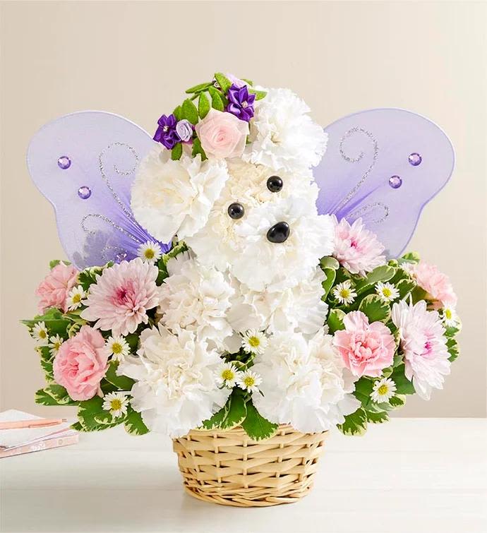 Basket arrangement shaped like a white puppy with pastel flowers and lavender fairy wings