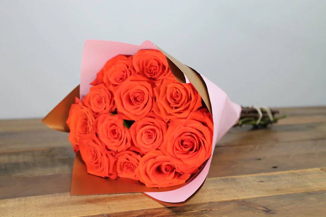 Passion Petals - Elegant arrangement of a dozen exquisite orange roses, beautifully presented in waterproof floral wrap to ensure lasting freshness.