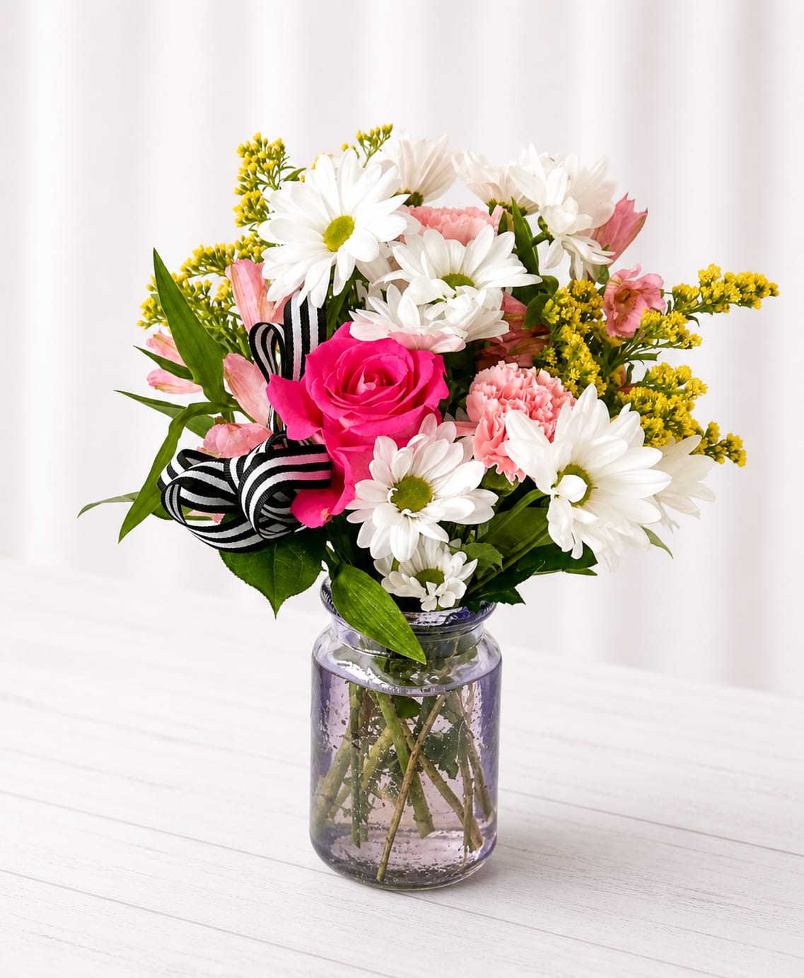 Pink rose and white daisy bouquet in a glass jar vase