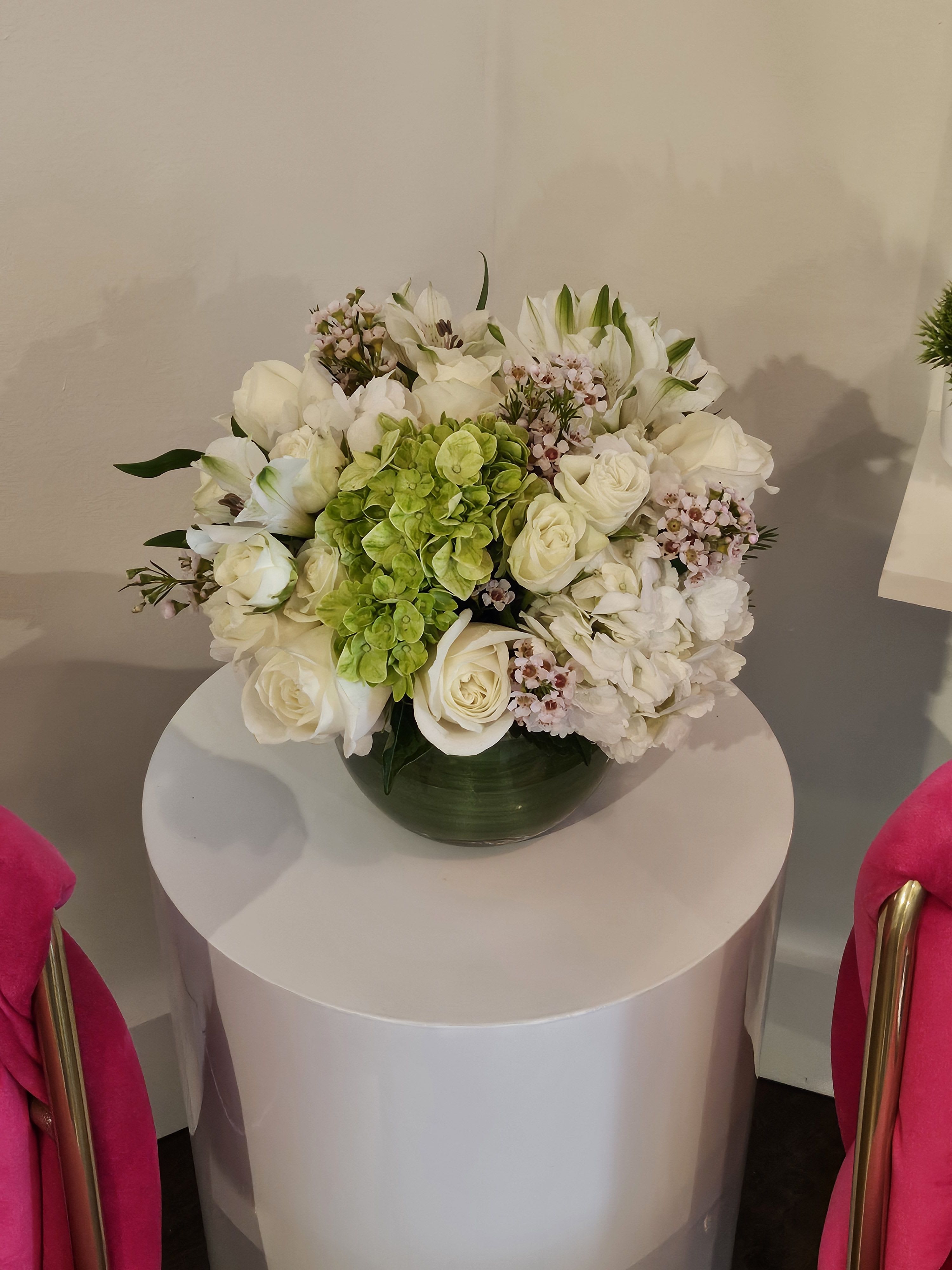 White floral arrangement with green hydrangea in a dark vase