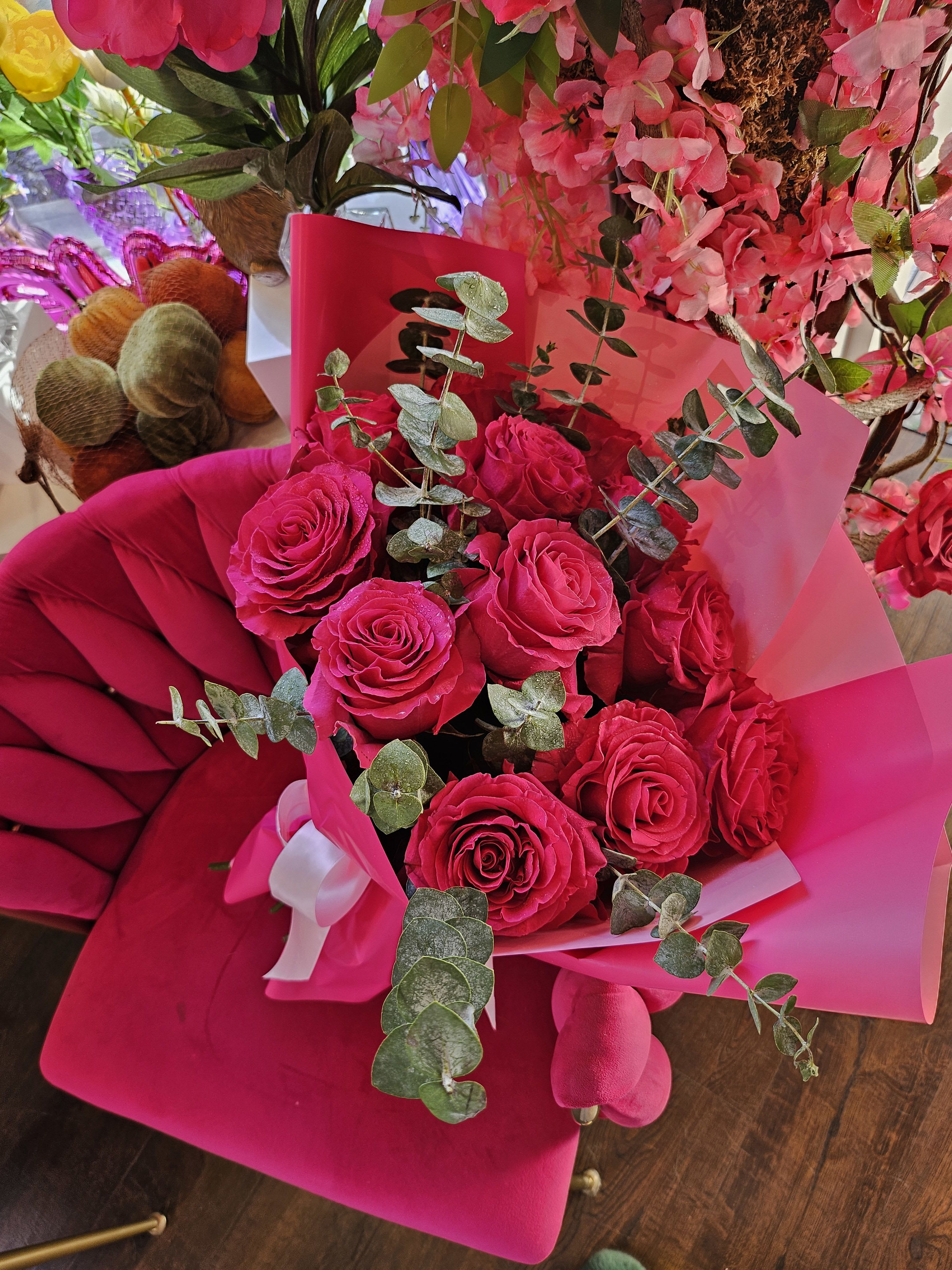 Bouquet of hot pink roses with eucalyptus in pink wrapping