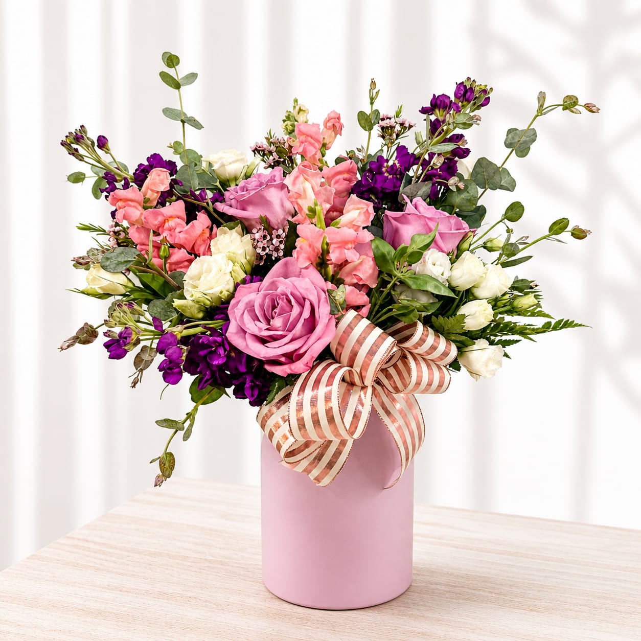 Debbie  - A lush, garden-style bouquet of pink roses, soft pink lisianthus and airy white blooms accented with deep purple highlights-arranged in a pink cylindrical vase-creates an immediately romantic and cheerful impression perfect for a birthday, anniversary, Mother's Day, or "just because" surprise. The rounded, layered composition and stems that fan outward give a natural, freshly-cut look that will make the person you're thinking of feel truly celebrated. 